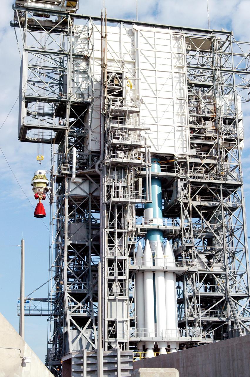 KENNEDY SPACE CENTER, FLA. -  The Boeing Delta II Heavy second-stage engine, the Aerojet AJ10-118K, is lifted up the mobile service tower on Pad 17-B, Cape Canaveral Air Force Station.  At right can be seen the first stage of the Delta II and the nine Solid Rocket Boosters surrounding it.  The Delta II is the launch vehicle for the MESSENGER (Mercury Surface, Space Environment, Geochemistry and Ranging) spacecraft, scheduled to lift off Aug. 2.  Bound for Mercury, the spacecraft is expected to reach orbit around the planet in March 2011.  MESSENGER was built for NASA by the Johns Hopkins University Applied Physics Laboratory in Laurel, Md.
