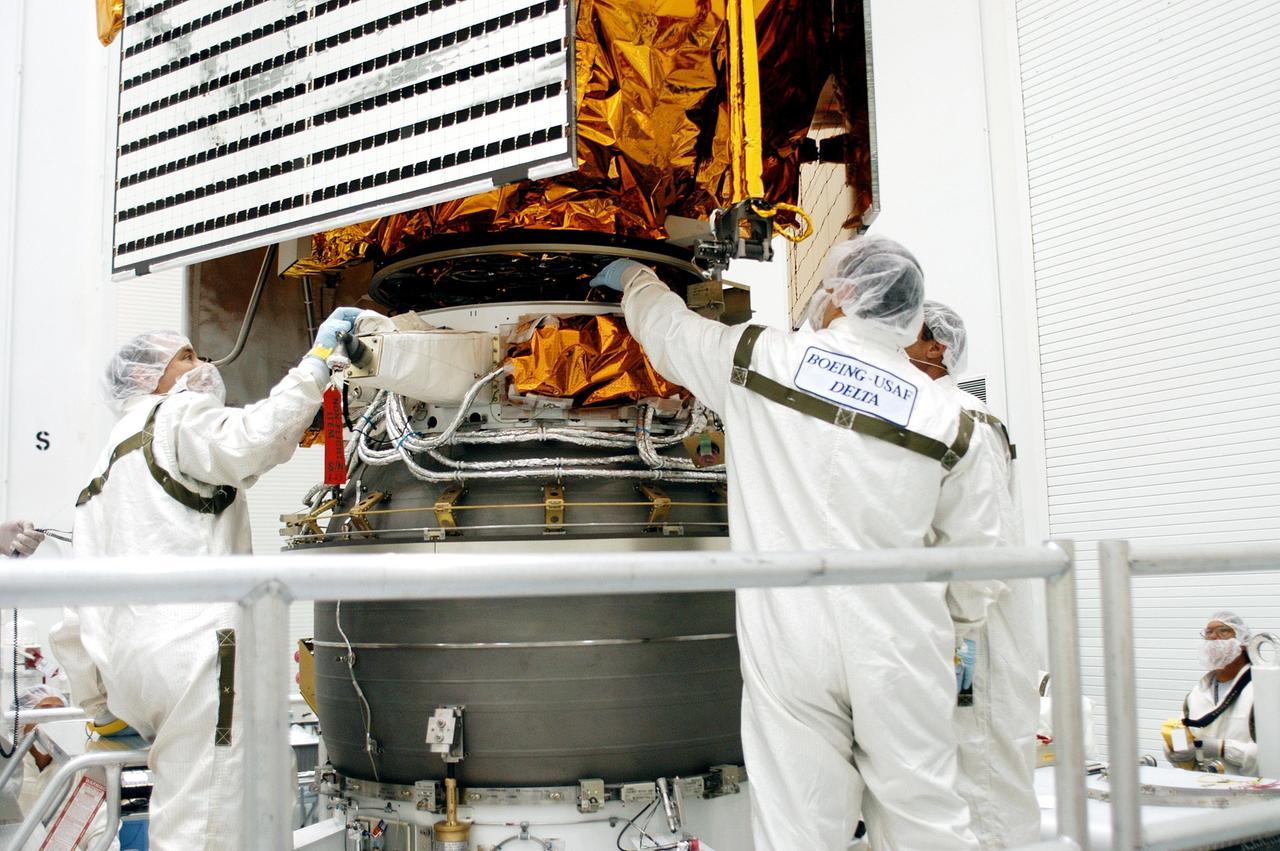 KENNEDY SPACE CENTER, FLA. - Technicians at Astrotech Space Operations in Titusville, Fla., watch closely as the MESSENGER spacecraft is lowered toward the Payload Assist Module, the Boeing Delta II third stage, below for mating. MESSENGER (Mercury Surface, Space Environment, Geochemistry and Ranging) is scheduled to launch Aug. 2 aboard a Boeing Delta II rocket from Pad 17-B, Cape Canaveral Air Force Station, Fla. It will return to Earth for a gravity boost in July 2005, then fly past Venus twice, in October 2006 and June 2007. It is expected to enter Mercury orbit in March 2011. MESSENGER was built for NASA by the Johns Hopkins University Applied Physics Laboratory in Laurel, Md.