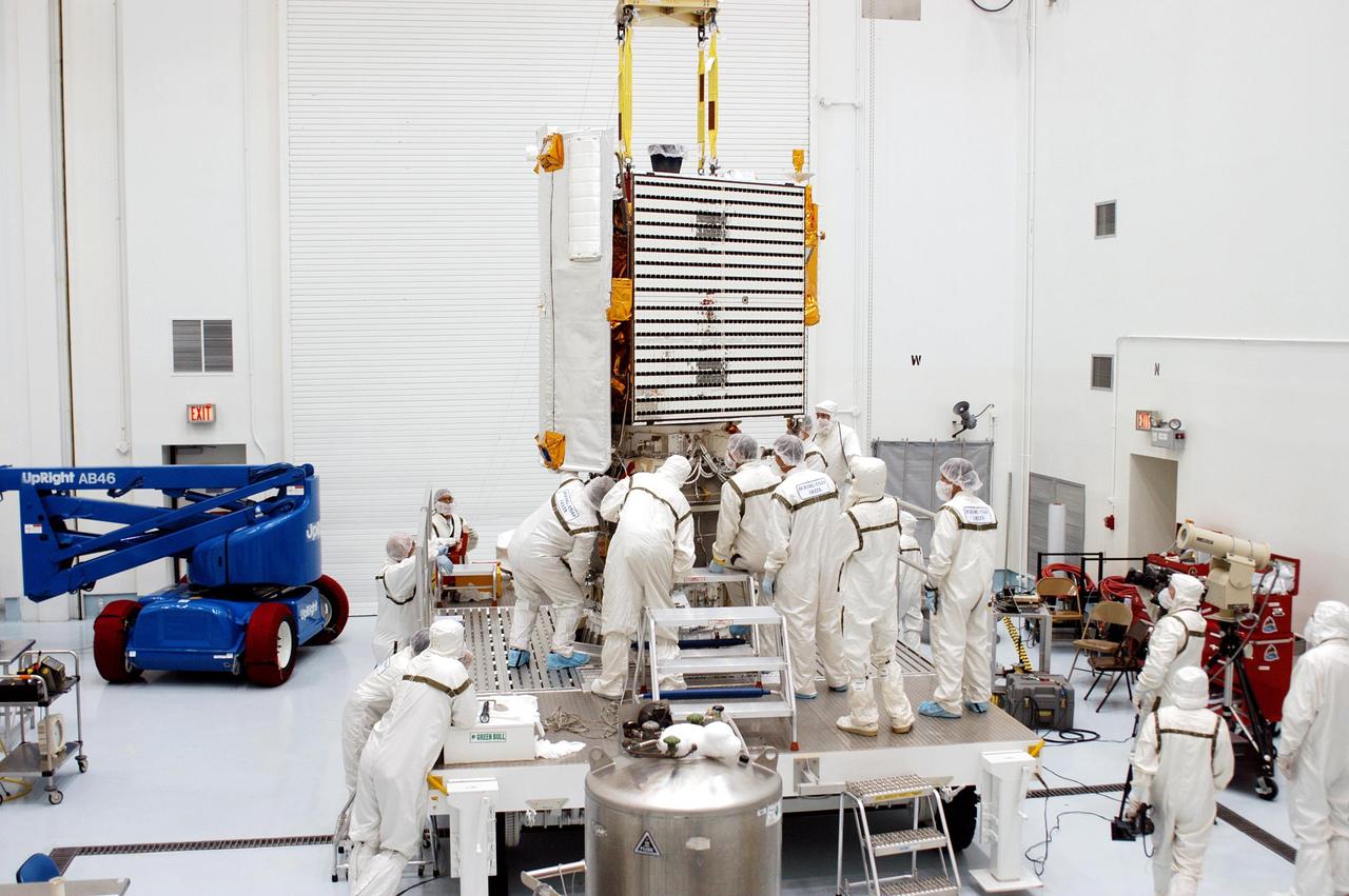 KENNEDY SPACE CENTER, FLA. -  Gathered on the work stand, technicians at Astrotech Space Operations in Titusville, Fla., check closely the mating of the MESSENGER spacecraft with the Payload Assist Module, the Boeing Delta II third stage, below it.  MESSENGER (Mercury Surface, Space Environment, Geochemistry and Ranging) is scheduled to launch Aug. 2 aboard a Boeing Delta II rocket from Pad 17-B, Cape Canaveral Air Force Station, Fla. It will return to Earth for a gravity boost in July 2005, then fly past Venus twice, in October 2006 and June 2007. It is expected to enter Mercury orbit in March 2011.  MESSENGER was built for NASA by the Johns Hopkins University Applied Physics Laboratory in Laurel, Md.