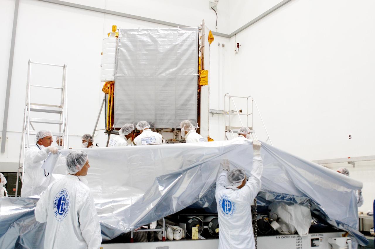 KENNEDY SPACE CENTER, FLA. - Workers from the Johns Hopkins University Applied Physics Laboratory in Laurel, Md. get ready to “bag” the MESSENGER (Mercury Surface, Space Environment, Geochemistry and Ranging) spacecraft in the background at Astrotech Space Operations in Titusville, Fla.  Placing a protective cover around the Mercury-bound MESSENGER precedes its placement in a transportation canister for the journey to Launch Pad 17-B at Cape Canaveral Air Force Station, Fla.  Liftoff of MESSENGER aboard a Boeing Delta II Heavy rocket is scheduled for Aug. 2.  The spacecraft is expected to reach orbit around the planet in March 2011.  MESSENGER was built for NASA by APL.