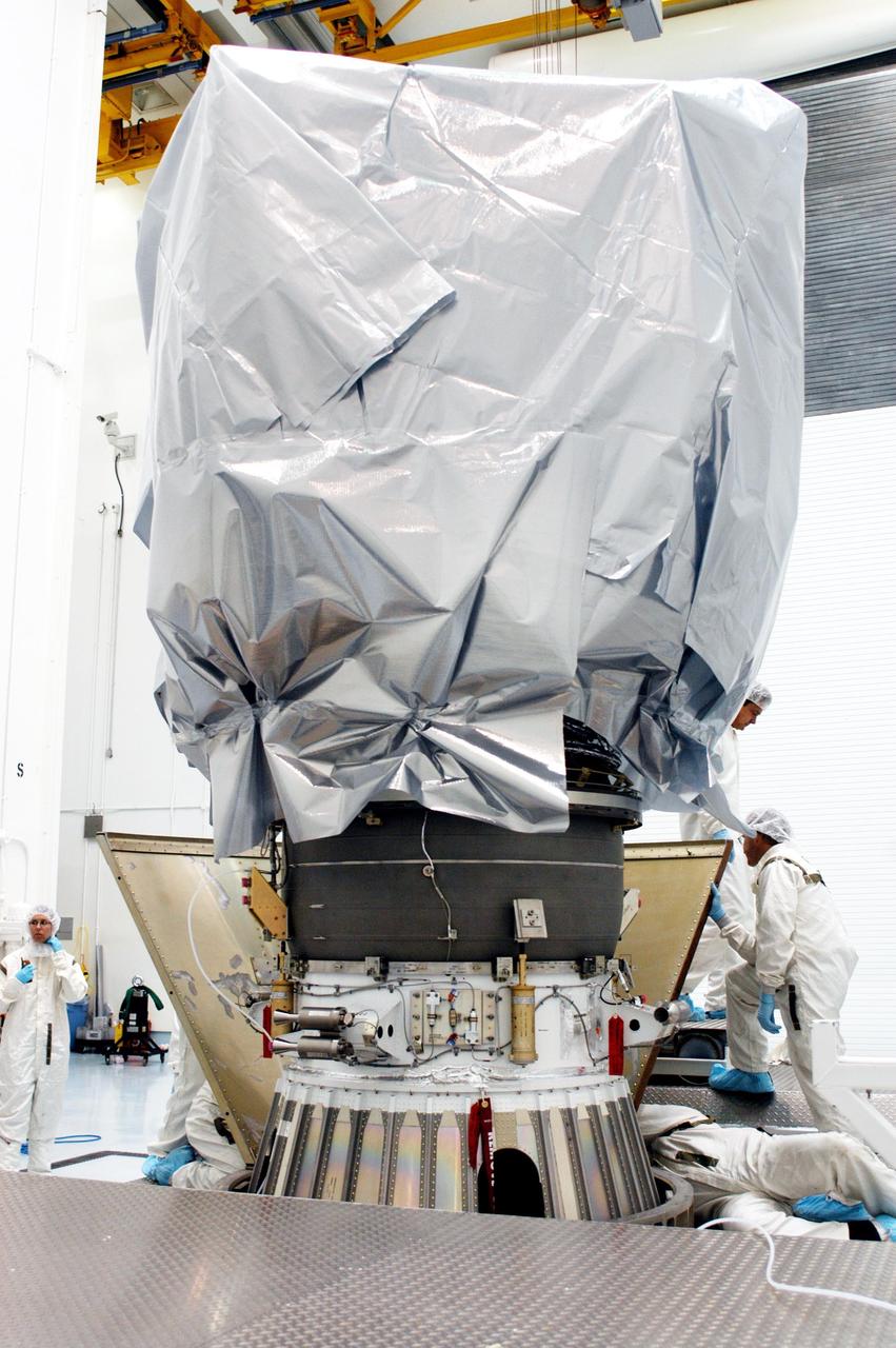 KENNEDY SPACE CENTER, FLA. - Boeing workers at Astrotech Space Operations in Titusville, Fla., secure the first part of a transportation canister around the Delta II upper stage booster on the MESSENGER (Mercury Surface, Space Environment, Geochemistry and Ranging) spacecraft.  MESSENGER will be transferred to Launch Pad 17-B at Cape Canaveral Air Force Station, Fla.  Liftoff of MESSENGER aboard a Boeing Delta II Heavy rocket is scheduled for Aug. 2.  The spacecraft is expected to reach orbit around the planet in March 2011.  MESSENGER was built for NASA by the Johns Hopkins University Applied Physics Laboratory in Laurel, Md.