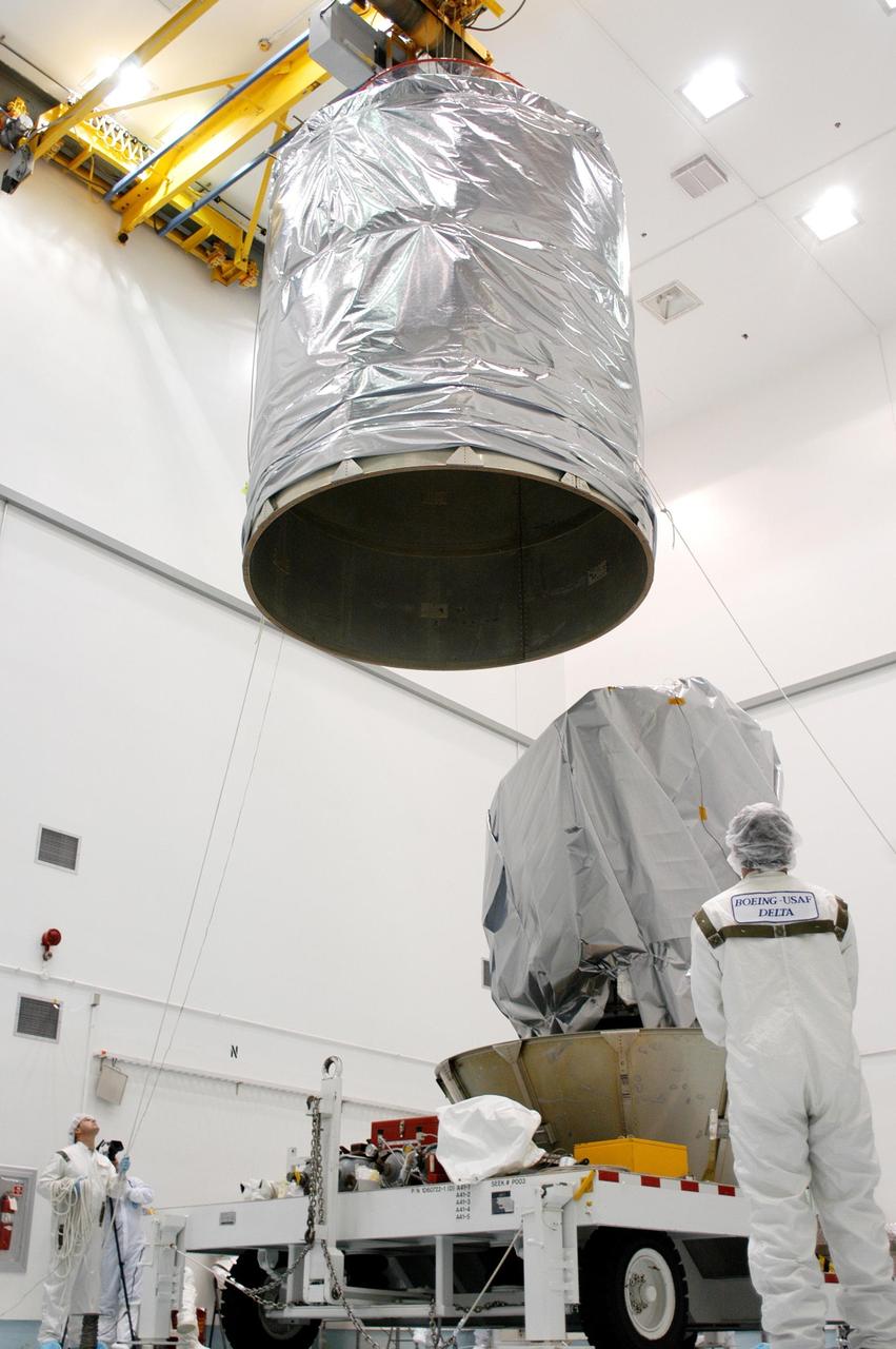 KENNEDY SPACE CENTER, FLA. - Boeing workers at Astrotech Space Operations in Titusville, Fla., watch the movement of the upper canister as it is lowered around the MESSENGER (Mercury Surface, Space Environment, Geochemistry and Ranging) spacecraft.  The canister will be attached to the lower protective panels around the Delta II  upper stage booster for the transportation of MESSENGER to Launch Pad 17-B at Cape Canaveral Air Force Station, Fla.  Liftoff of MESSENGER aboard a Boeing Delta II Heavy rocket is scheduled for Aug. 2.  The spacecraft is expected to reach orbit around the planet in March 2011.  MESSENGER was built for NASA by the Johns Hopkins University Applied Physics Laboratory in Laurel, Md.