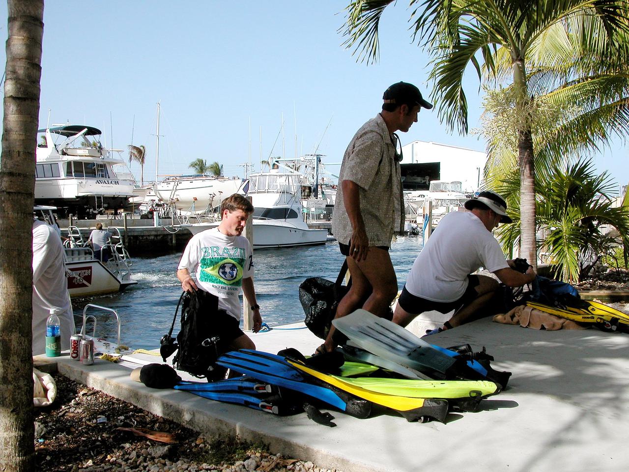 KENNEDY SPACE CENTER, FLA. - After their return from a practice dive at the NOAA Aquarius underwater station offshore at Key Largo, Marc Reagan, John Herrington and Nick Patrick unload dive gear.  Herrington is mission commander and Patrick is a member of the crew on the NASA Extreme Environment Mission Operations 6 (NEEMO-6) mission.  Reagan is mission lead as well as underwater still photographer.  The NEEMO-6 mission involves exposing an astronaut/scientist crew to a real mission experience in an extreme environment - the NOAA undersea station Aquarius offshore from Key Largo - to prepare for future space flight.  Spacewalk-like diving excursions and field-tests on a variety of biomedical equipment are designed to help astronauts living aboard the International Space Station.  Other team members are Doug Wheelock and biomedical engineer Tara Ruttley. To prepare for their 10-day stay, the team had dive training twice a day at the Life Support Buoy, anchored above Aquarius.
