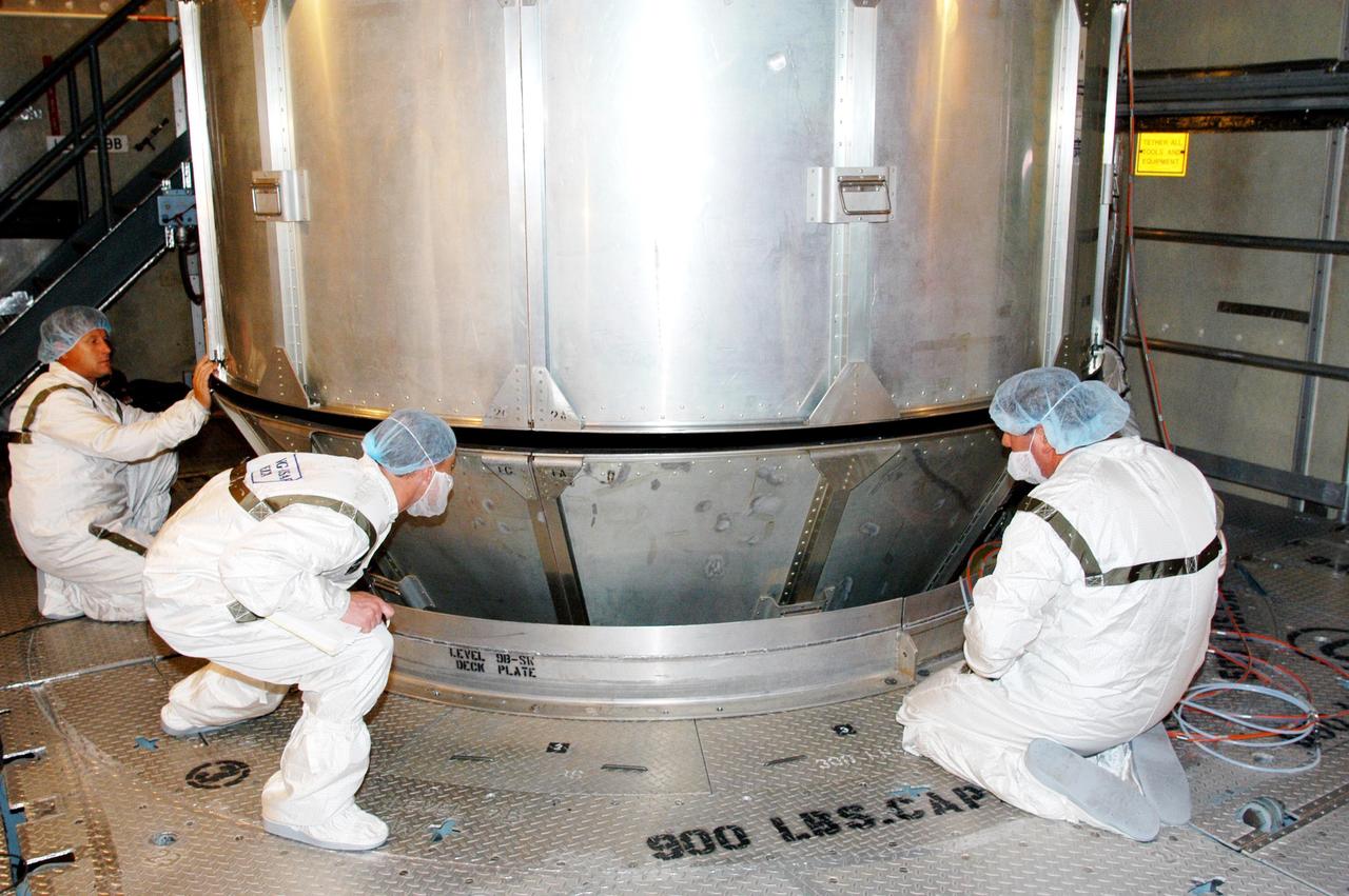 KENNEDY SPACE CENTER, FLA. - In the mobile service tower at Launch Complex 17-B, Cape Canaveral Air Force Station, workers watch closely as the upper canister around the MESSENGER (Mercury Surface, Space Environment, Geochemistry and Ranging) spacecraft is detached from the lower panels. MESSENGER is scheduled to launch Aug. 2. It will return to Earth for a gravity boost in July 2005, then fly past Venus twice, in October 2006 and June 2007. It is expected to enter Mercury orbit in March 2011. MESSENGER was built for NASA by the Johns Hopkins University Applied Physics Laboratory in Laurel, Md. Processing is being done at Astrotech Space Operations in Titusville, Fla.