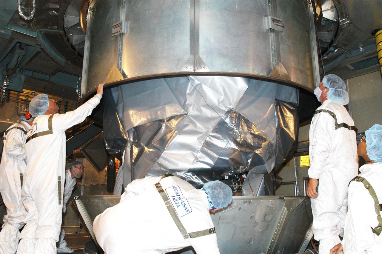 KENNEDY SPACE CENTER, FLA. - In the mobile service tower at Launch Complex 17-B, Cape Canaveral Air Force Station, workers oversee removal of the canister from around the MESSENGER (Mercury Surface, Space Environment, Geochemistry and Ranging) spacecraft. Scheduled to launch Aug. 2, MESSENGER will return to Earth for a gravity boost in July 2005, then fly past Venus twice, in October 2006 and June 2007. It is expected to enter Mercury orbit in March 2011. MESSENGER was built for NASA by the Johns Hopkins University Applied Physics Laboratory in Laurel, Md. Processing is being done at Astrotech Space Operations in Titusville, Fla.
