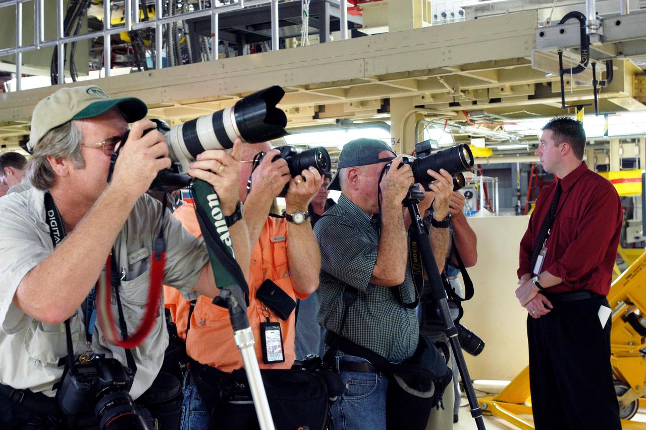 KENNEDY SPACE CENTER, FLA. -   Media tour the Orbiter Processing Facility (OPF) housing the Space Shuttle Discovery at KSC. During this event, they received the latest information on Discovery’s processing and viewed workers preparing the vehicle for its safe return to flight scheduled for a launch planning window of March 2005.  Kicking off the activities at the Press Site Auditorium, technical experts led two workshops addressing Reinforced Carbon-Carbon and vehicle instrumentation.  Later, reporters toured the OPF to see work in progress on Discovery, including reinstallation of the Reinforced Carbon-Carbon panels on the Shuttle's wing leading edge, wiring inspections and instrumentation updates being completed for Return to Flight.