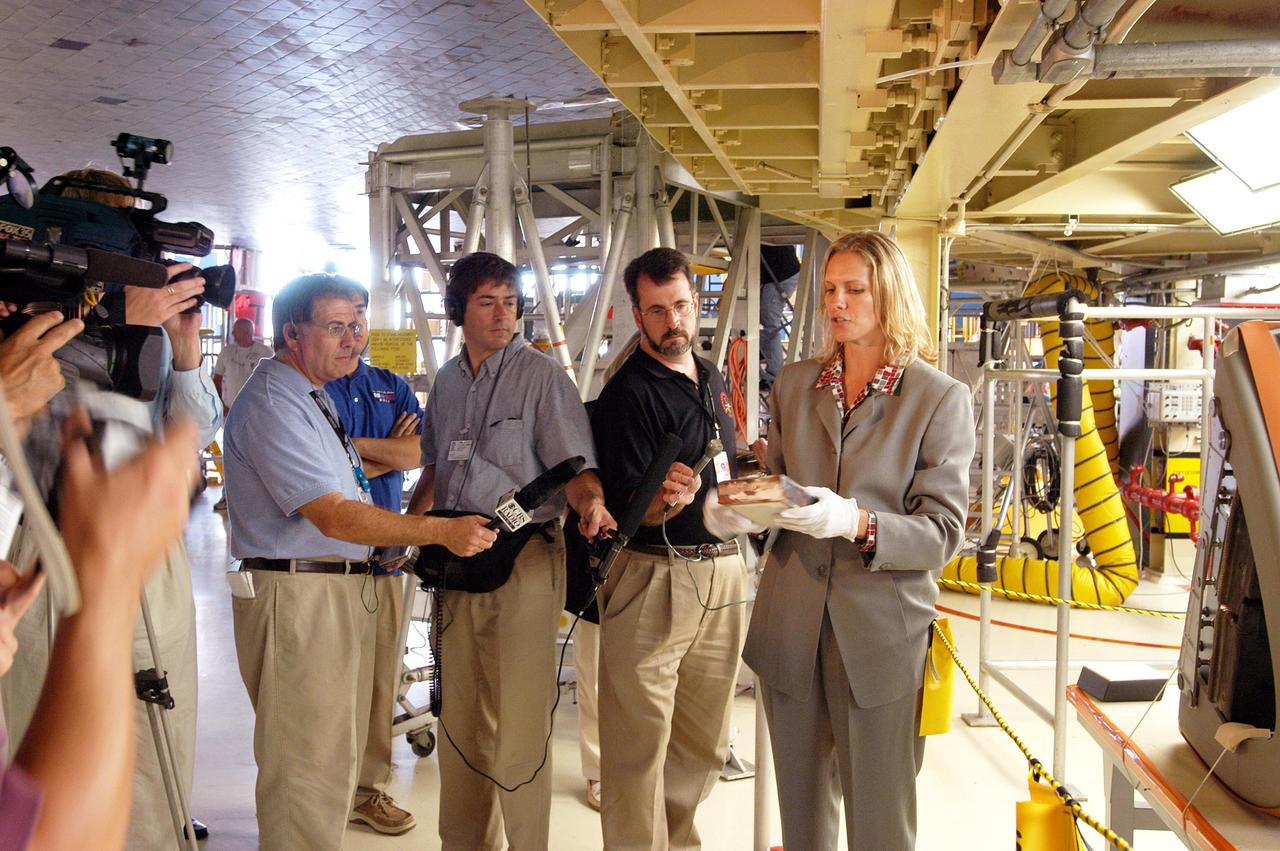 KENNEDY SPACE CENTER, FLA. -   Stephanie Stilson (right), NASA Vehicle Manager, briefs the media attending an informative workshop and tour of the Orbiter Processing Facility (OPF) housing the Space Shuttle Discovery at KSC. During this event, the media received the latest information on Discovery’s processing and viewed workers preparing the vehicle for its safe return to flight scheduled for a launch planning window of March 2005.  Kicking off the activities at the Press Site Auditorium, technical experts led two workshops addressing Reinforced Carbon-Carbon and vehicle instrumentation.  During the tour of the OPF, reporters saw work in progress on Discovery, including reinstallation of the Reinforced Carbon-Carbon panels on the Shuttle's wing leading edge, wiring inspections and instrumentation updates being completed for Return to Flight.