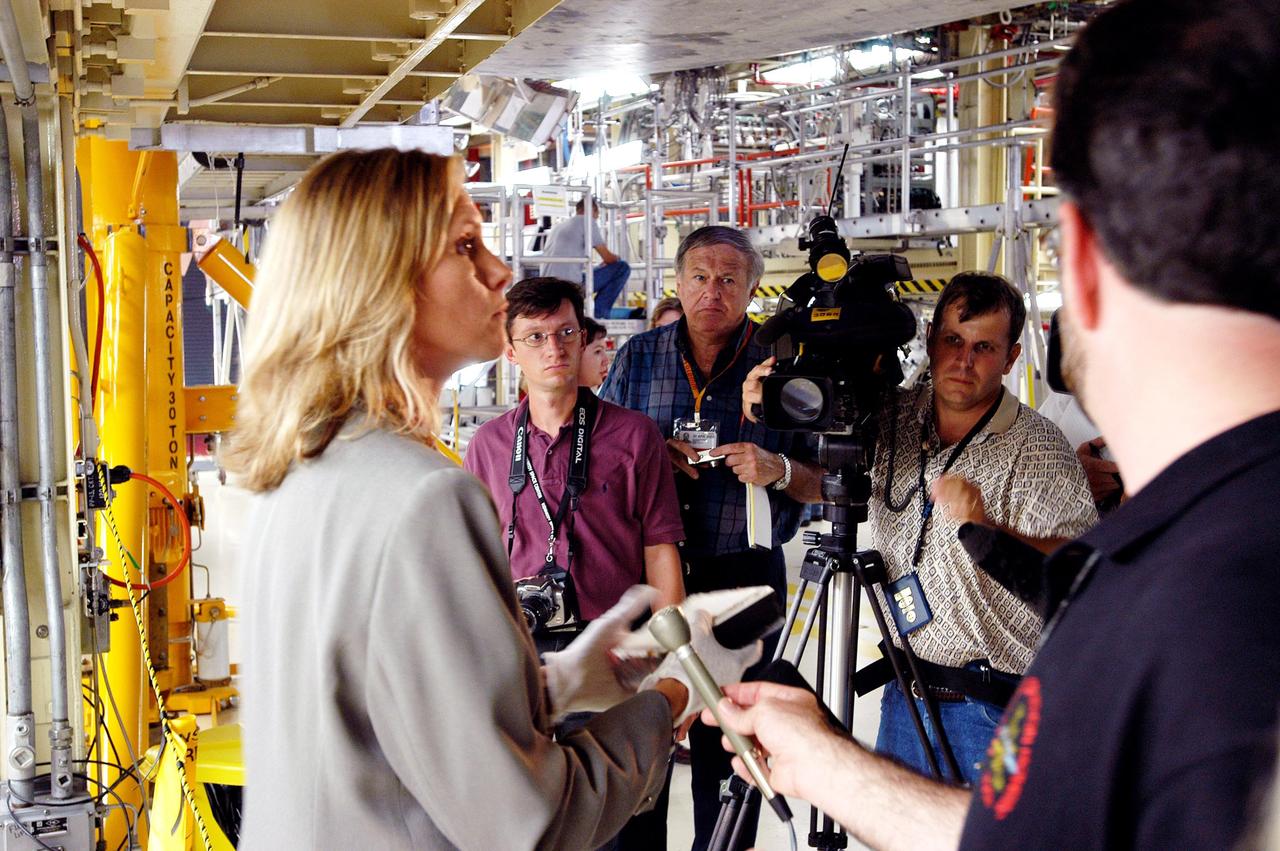 KENNEDY SPACE CENTER, FLA. -   Stephanie Stilson (left), NASA Vehicle Manager, briefs the media attending an informative workshop and tour of the Orbiter Processing Facility (OPF) housing the Space Shuttle Discovery at KSC. During this event, the media received the latest information on Discovery’s processing and viewed workers preparing the vehicle for its safe return to flight scheduled for a launch planning window of March 2005.  Kicking off the activities at the Press Site Auditorium, technical experts led two workshops addressing Reinforced Carbon-Carbon and vehicle instrumentation.  During the tour of the OPF, reporters saw work in progress on Discovery, including reinstallation of the Reinforced Carbon-Carbon panels on the Shuttle's wing leading edge, wiring inspections and instrumentation updates being completed for Return to Flight.