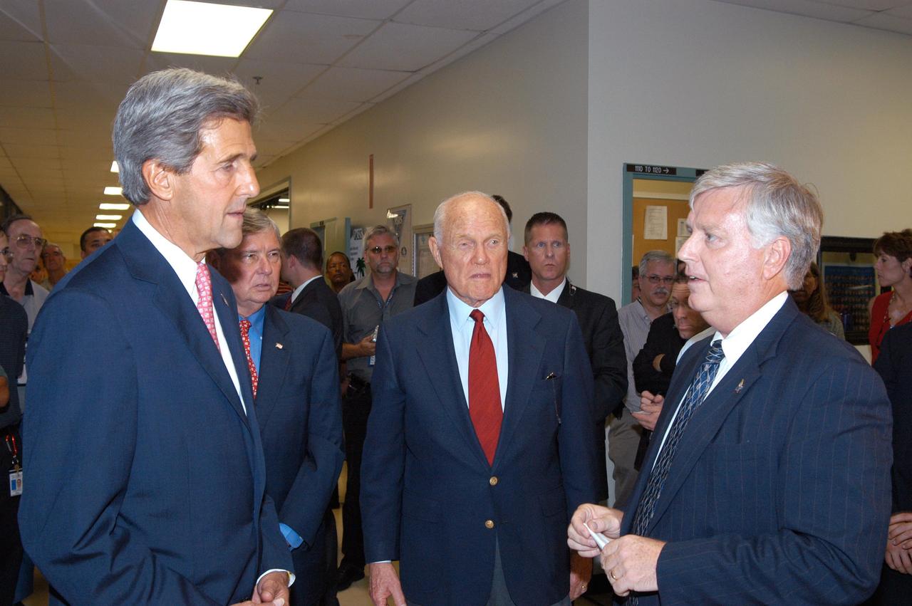 KENNEDY SPACE CENTER, FLA. - From left, Sen. John F. Kerry, D-Mass., Sen. Bob Graham, D-Fla., and former astronaut and Sen. John H. Glenn, D-Ohio, receive a briefing from Kennedy Space Center Director James W. Kennedy before a tour of the Orbiter Processing Facility (OPF). In the OPF, the orbiter Discovery is being prepared for flight on the next Space Shuttle mission. The tour follows a public meeting Kerry held at the Dr. Kurt H. Debus Conference Facility at the Kennedy Space Center Visitor Complex. He said he chose to speak at KSC because it symbolizes America’s commitment to science, innovation and technology. He and Sen. John Edwards, D-N.C., are on a speaking tour prior to their appearance at the Democratic National Convention in Boston.