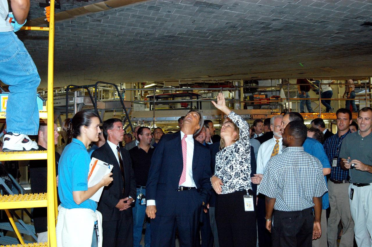KENNEDY SPACE CENTER, FLA. - Sen. John F. Kerry (center), D-Mass., discusses Space Shuttle processing with NASA Vehicle Manager Stephanie Stilson during a tour of the Orbiter Processing Facility (OPF). They are standing under the orbiter Discovery, which is being prepared for flight on the next Space Shuttle mission. The tour follows a public meeting Kerry held at the Dr. Kurt H. Debus Conference Facility at the Kennedy Space Center Visitor Complex. He said he chose to speak at KSC because it symbolizes America’s commitment to science, innovation and technology. He and Sen. John Edwards, D-N.C., are on a speaking tour prior to their appearance at the Democratic National Convention in Boston.