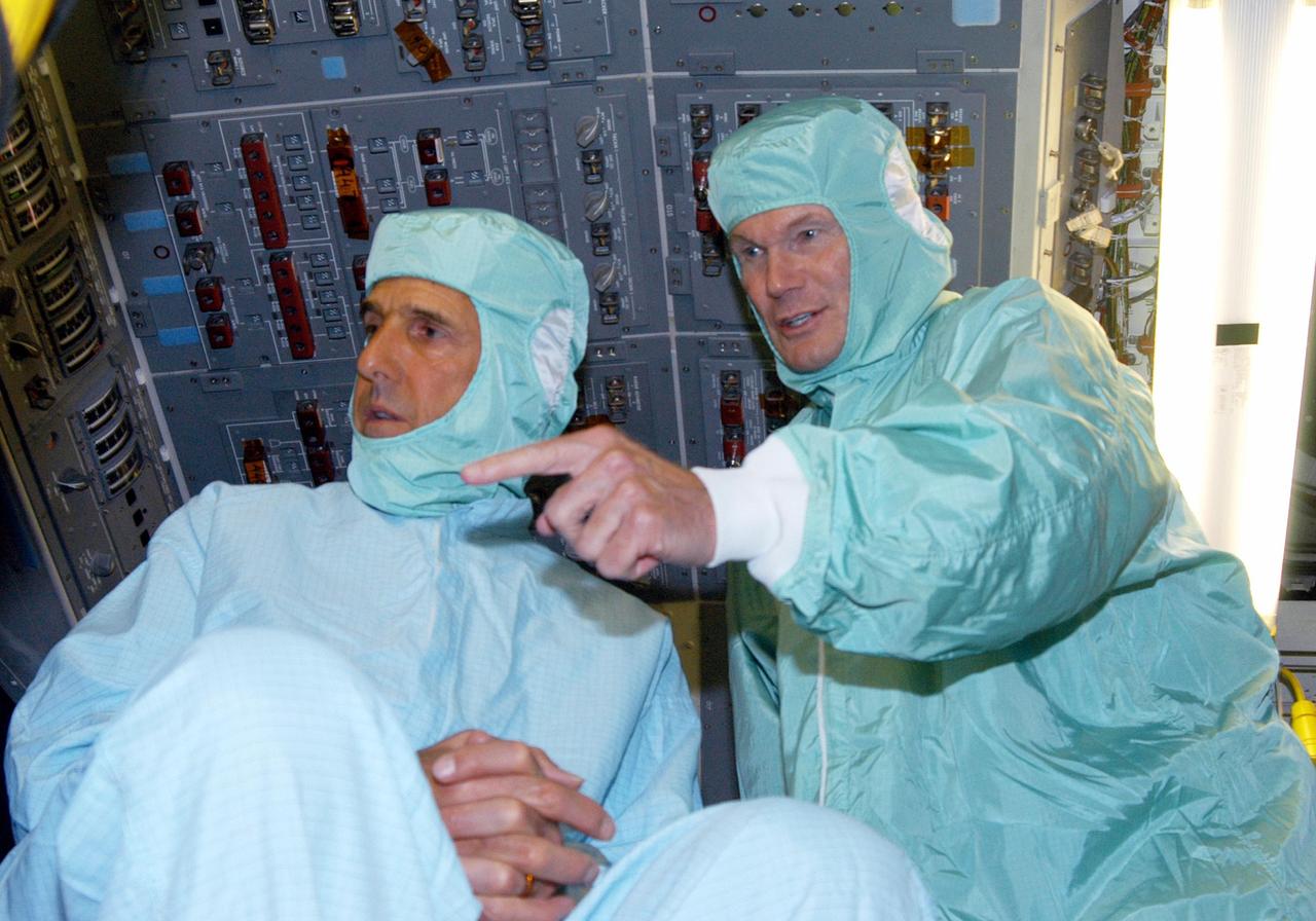 KENNEDY SPACE CENTER, FLA. - Sen. John F. Kerry (left), D-Mass., and Sen. Bill Nelson, D-Fla., dressed in clean room attire, visit the flight deck of Space Shuttle Discovery during a tour of the Orbiter Processing Facility (OPF). The “bunny suits” are required dress for anyone coming in close proximity to Discovery, currently being prepared for flight on the next Space Shuttle mission. The tour of the OPF follows a public meeting Kerry held at the Dr. Kurt H. Debus Conference Facility at the Kennedy Space Center Visitor Complex.  He said he chose to speak at KSC because it symbolizes America’s commitment to science, innovation and technology. He and Sen. John Edwards, D-N.C., are on a speaking tour prior to their appearance at the Democratic National Convention in Boston.