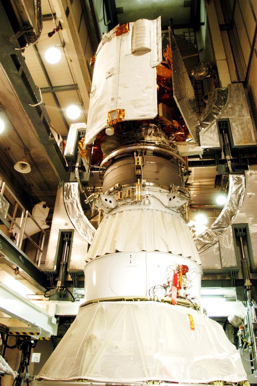 KENNEDY SPACE CENTER, FLA. - On Launch Pad 17-B at Cape Canaveral Air Force Station, the MESSENGER (Mercury Surface, Space Environment, Geochemistry and Ranging) spacecraft is seen atop the Delta II upper stage booster (middle) and the Delta II launch vehicle below. The spacecraft is ready for installation of the fairing, a molded structure that fits flush with the outside surface of the upper stage booster and forms an aerodynamically smooth joint, protecting the spacecraft during launch. Seen on the right is one of the solar panels on the spacecraft. On the left is the heat-resistant, ceramic-cloth sunshade that will protect the spacecraft’s instruments as MESSENGER orbits the Mercury where the surface reaches a high temperature near 840 degrees Fahrenheit and the solar intensity can be 11 times greater than on Earth. MESSENGER is scheduled to launch Aug. 2 and is expected to enter Mercury orbit in March 2011. MESSENGER was built for NASA by the Johns Hopkins University Applied Physics Laboratory in Laurel, Md.