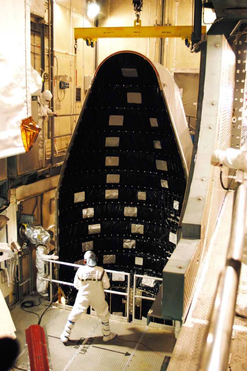 KENNEDY SPACE CENTER, FLA. - On Launch Pad 17-B at Cape Canaveral Air Force Station, part of the fairing for the MESSENGER (Mercury Surface, Space Environment, Geochemistry and Ranging) spacecraft is moved into place for installation.  The fairing is a molded structure that fits flush with the outside surface of the upper stage booster and forms an aerodynamically smooth joint, protecting the spacecraft during launch.  MESSENGER  is scheduled to launch Aug. 2 aboard a Boeing Delta II rocket and is expected to enter Mercury orbit in March 2011.  MESSENGER was built for NASA by the Johns Hopkins University Applied Physics Laboratory in Laurel, Md.