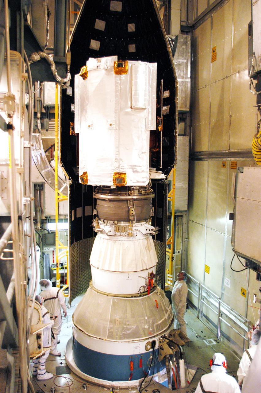 KENNEDY SPACE CENTER, FLA. - On Launch Pad 17-B at Cape Canaveral Air Force Station, Boeing workers check the progress of the fairing as it is moved into place for installation around the MESSENGER (Mercury Surface, Space Environment, Geochemistry and Ranging) spacecraft.  The fairing is a molded structure that fits flush with the outside surface of the upper stage booster and forms an aerodynamically smooth joint, protecting the spacecraft during launch.  MESSENGER  is scheduled to launch Aug. 2 aboard a Boeing Delta II rocket and is expected to enter Mercury orbit in March 2011.  MESSENGER was built for NASA by the Johns Hopkins University Applied Physics Laboratory in Laurel, Md.