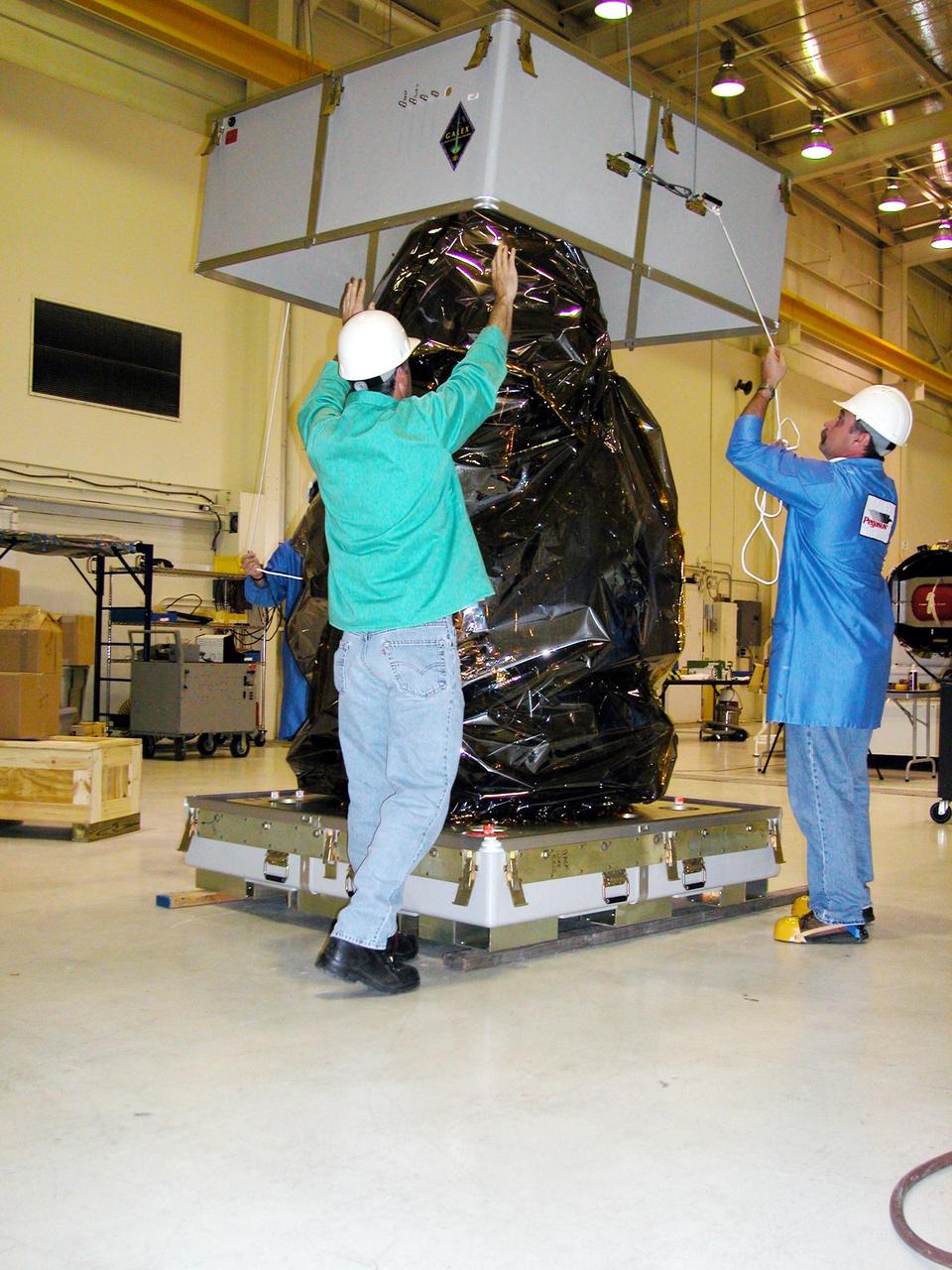 KENNEDY SPACE CENTER, FLA. - At Vandenberg Air Force Base in California, Orbital Sciences workers remove the canister from the DART (Demonstration for Autonomous Rendezvous Technology) flight demonstrator, a spacecraft developed to prove technologies for locating and maneuvering near an orbiting satellite.  Future applications of technologies developed by the DART project will benefit the nation in future space-vehicle systems development requiring in-space assembly, services or other autonomous rendezvous operations.  Designed and developed for NASA by Orbital Sciences Corporation in Dulles, Va., the DART spacecraft will be launched on a Pegasus launch vehicle. At about 40,000 feet over the Pacific Ocean, the Pegasus will be released from Orbital’s Stargazer L-1011 aircraft, fire its rocket motors and boost DART into a polar orbit approximately 472 miles by 479 miles. Once in orbit, DART will rendezvous with a target satellite, the Multiple Paths, Beyond-Line-of-Site Communications satellite, also built by Orbital Sciences. DART will then perform several close proximity operations, such as moving toward and away from the satellite using navigation data provided by onboard sensors.  DART is scheduled for launch no earlier than Oct. 18.