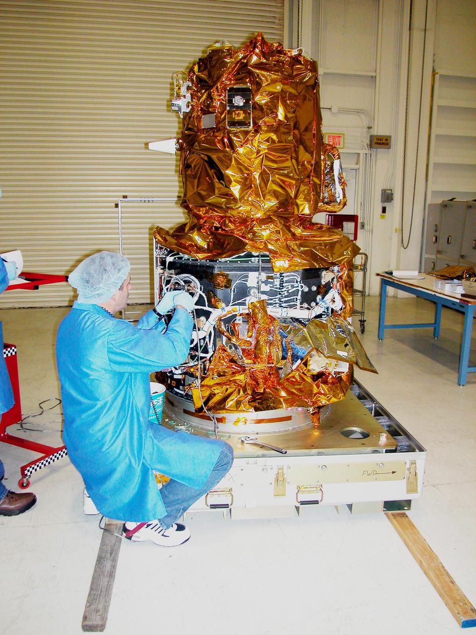 KENNEDY SPACE CENTER, FLA. - At Vandenberg Air Force Base in California, an Orbital Sciences technician works with wiring on the DART (Demonstration for Autonomous Rendezvous Technology) flight demonstrator, a spacecraft developed to prove technologies for locating and maneuvering near an orbiting satellite.  Future applications of technologies developed by the DART project will benefit the nation in future space-vehicle systems development requiring in-space assembly, services or other autonomous rendezvous operations.  Designed and developed for NASA by Orbital Sciences Corporation in Dulles, Va., the DART spacecraft will be launched on a Pegasus launch vehicle. At about 40,000 feet over the Pacific Ocean, the Pegasus will be released from Orbital’s Stargazer L-1011 aircraft, fire its rocket motors and boost DART into a polar orbit approximately 472 miles by 479 miles. Once in orbit, DART will rendezvous with a target satellite, the Multiple Paths, Beyond-Line-of-Site Communications satellite, also built by Orbital Sciences. DART will then perform several close proximity operations, such as moving toward and away from the satellite using navigation data provided by onboard sensors.  DART is scheduled for launch no earlier than Oct. 18.