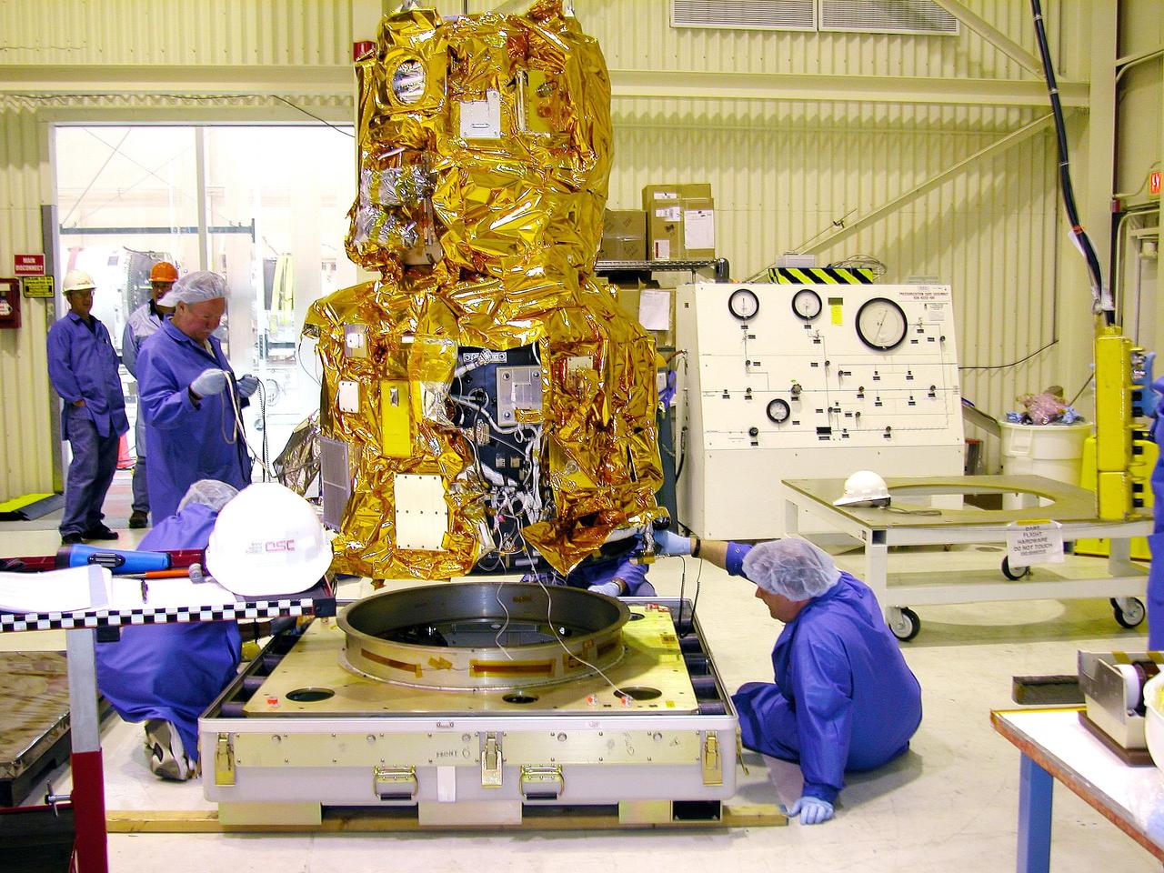 KENNEDY SPACE CENTER, FLA. - At Vandenberg Air Force Base in California, Orbital Sciences technicians check the bottom of the DART (Demonstration for Autonomous Rendezvous Technology) flight demonstrator as it is raised of its platform.  The spacecraft was developed to prove technologies for locating and maneuvering near an orbiting satellite.  Future applications of technologies developed by the DART project will benefit the nation in future space-vehicle systems development requiring in-space assembly, services or other autonomous rendezvous operations.  Designed and developed for NASA by Orbital Sciences Corporation in Dulles, Va., the DART spacecraft will be launched on a Pegasus launch vehicle. At about 40,000 feet over the Pacific Ocean, the Pegasus will be released from Orbital’s Stargazer L-1011 aircraft, fire its rocket motors and boost DART into a polar orbit approximately 472 miles by 479 miles. Once in orbit, DART will rendezvous with a target satellite, the Multiple Paths, Beyond-Line-of-Site Communications satellite, also built by Orbital Sciences. DART will then perform several close proximity operations, such as moving toward and away from the satellite using navigation data provided by onboard sensors.  DART is scheduled for launch no earlier than Oct. 18.