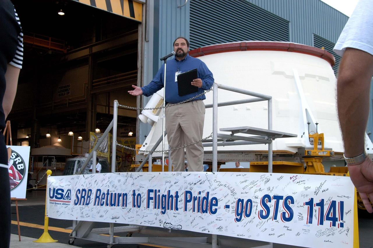KENNEDY SPACE CENTER, FLA. - Paul Gutierrez, United Space Alliance associate program manager for the Solid Rocket Booster Element, congratulates employees in the Assembly and Refurbishment Facility for preparing the first (left) solid rocket booster (SRB) aft skirt for mission STS-114 on schedule.  The segment, seen behind Gutierrez, will be transferred to the Rotation Processing and Surge Facility (RPSF) for stacking.  At the RPSF an aft motor segment and an external tank attach ring will be installed.  The stack will then be moved to the Vehicle Assembly Building for further build-up.  This is the first transfer of a large piece of hardware from SRB to Ground Operations.  It is a significant milestone in the march to Return to Flight.