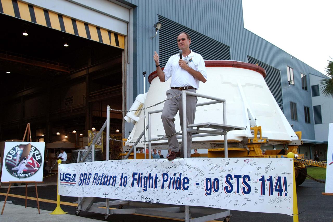 KENNEDY SPACE CENTER, FLA. - Space Shuttle Deputy Program Manager Mike Rudolphi, from Marshall Space Flight Center, congratulates employees in the Assembly and Refurbishment Facility for preparing the first (left) solid rocket booster aft skirt for mission STS-114 on schedule.  The segment, seen behind Rudolphi, will be transferred to the Rotation Processing and Surge Facility (RPSF) for stacking.  At the RPSF an aft motor segment and an external tank attach ring will be installed.  The stack will then be moved to the Vehicle Assembly Building for further build-up. This is the first transfer of a large piece of hardware from SRB to Ground Operations.  It is a significant milestone in the march to Return to Flight.