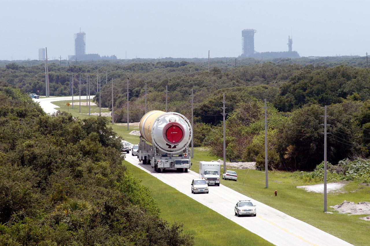 KENNEDY SPACE CENTER, FLA. - A Security escort leads the way as this Boeing Delta IV first stage heads to the Horizontal Integration Facility at Launch Complex 37, Cape Canaveral Air Force Station.  Two of the launch pads on Cape Canaveral’s coast can be seen in the background.  Two rockets were shipped by barge from Decatur, Ala., to Port Canaveral and offloaded onto Elevating Platform Transporters.  A Boeing Delta IV will be used for the December launching of the GOES-N weather satellite for NASA and NOAA. The GOES-N is the first in a series of three advanced weather satellites including GOES-O and GOES-P. This satellite will provide continuous monitoring necessary for intensive data analysis. It will provide a constant vigil for the atmospheric “triggers” of severe weather conditions such as tornadoes, flash floods, hail storms and hurricanes. When these conditions develop, GOES-N will be able to monitor storm development and track their movements.
