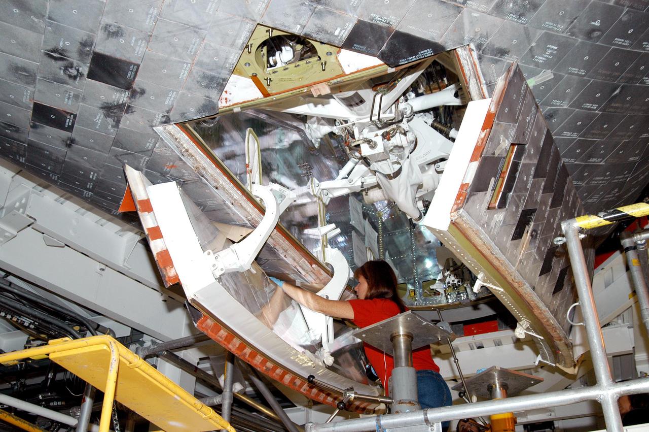 KENNEDY SPACE CENTER, FLA. -  Workers in the Orbiter Processing Facility prepare to close the nose wheel doors on Atlantis in preparation for the expected impact of Hurricane Frances on Saturday. Preparations at KSC include powering down the Space Shuttle orbiters, closing their payload bay doors and stowing their landing gear. They are also taking precautions against flooding by moving spacecraft hardware off the ground and sandbagging facilities. The Orbiter Processing Facility is constructed of concrete and steel and was designed to withstand winds of 105 mph.  The Vehicle Assembly Building is constructed of concrete and steel and was designed to withstand winds of 125 mph. Other payload and flight hardware support facilities can endure winds of 110 mph.  Launch pads and the Payload Hazardous Servicing Facility can withstand 125-mph winds.