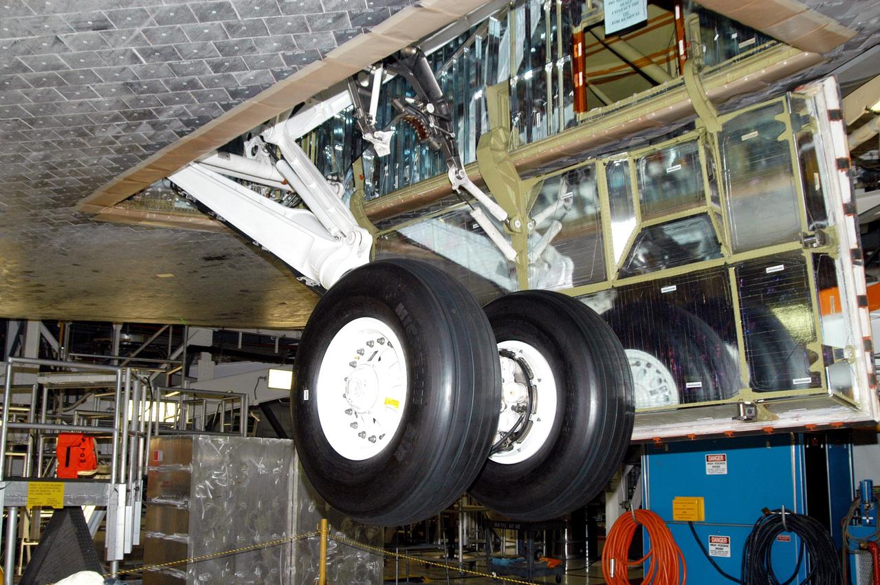 KENNEDY SPACE CENTER, FLA. - In the Orbiter Processing Facility, Atlantis’ wheels are raised into their wheel bays in preparation for the expected impact of Hurricane Frances on Saturday. Other preparations at KSC include powering down the Space Shuttle orbiters, and closing their payload bay doors. Workers are also taking precautions against flooding by moving spacecraft hardware off the ground and sandbagging facilities. The Orbiter Processing Facility is constructed of concrete and steel and was designed to withstand winds of 105 mph. The Vehicle Assembly Building is constructed of concrete and steel and was designed to withstand winds of 125 mph. Other payload and flight hardware support facilities can endure winds of 110 mph. Launch pads and the Payload Hazardous Servicing Facility can withstand 125-mph winds.
