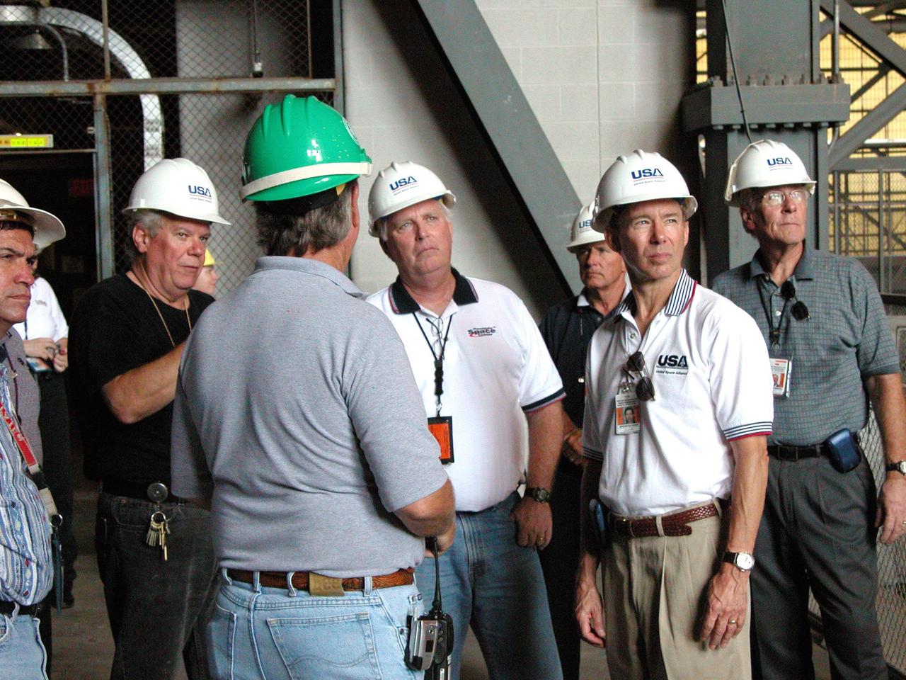 KENNEDY SPACE CENTER, FLA. - Members of the United Space Alliance (USA) safety team brief KSC Director Jim Kennedy (center), USA Chief Operating Officer Brewster Shaw (second from right), and USA Vice President Joe Hammond (right) following Hurricane Frances on damage sustained by KSC facilities. The storm's path over Florida took it through Cape Canaveral and KSC property during Labor Day weekend.