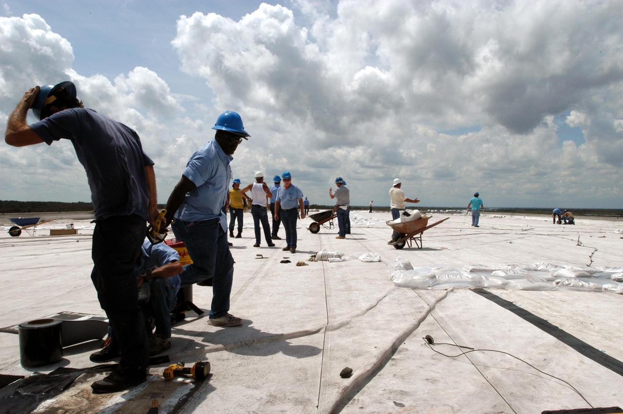 KENNEDY SPACE CENTER, FLA. -  KSC employees begin the work to clean up and secure the roof of the Processing Control Center which sustained damage from Hurricane Frances. The storm's path over Florida took it through Cape Canaveral and KSC property during Labor Day weekend. Located in Launch Complex 39, the facility houses some of the staff and computers responsible for Launch Processing System (LPS) software development, launch team training, and LPS maintenance.