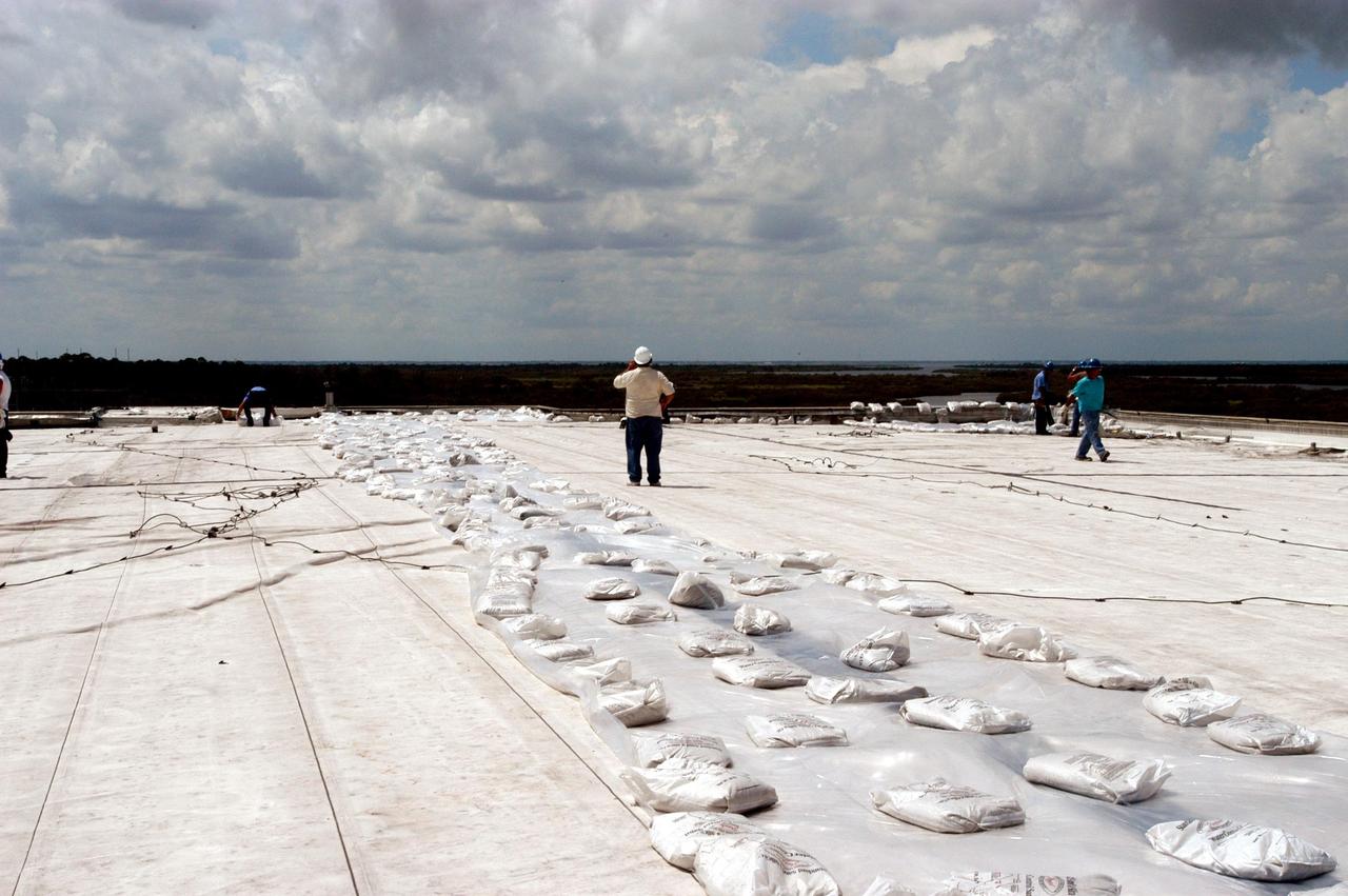 KENNEDY SPACE CENTER, FLA. -  The work to clean up and secure the roof of the Processing Control Center which sustained damage from Hurricane Frances is under way. The storm's path over Florida took it through Cape Canaveral and KSC property during Labor Day weekend. Located in Launch Complex 39, the facility houses some of the staff and computers responsible for Launch Processing System (LPS) software development, launch team training, and LPS maintenance.