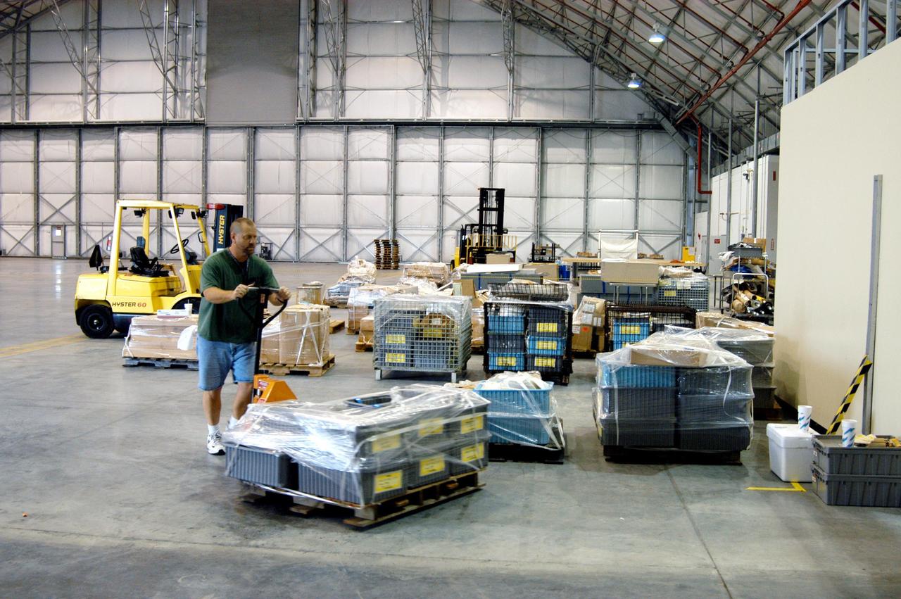 KENNEDY SPACE CENTER, FLA. -   A KSC employee moves equipment from the Thermal Protection System Facility (TPSF), damaged by Hurricane Frances, into a hangar and storage facility near the KSC Shuttle Landing Facility. Previously, this hangar was used to house the Space Shuttle Columbia debris. Located in Launch Complex 39, the TPSF is used to manufacture both internal and external insulation products for the Space Shuttle orbiters.  The storm's path over Florida took it through Cape Canaveral and KSC property during Labor Day weekend.