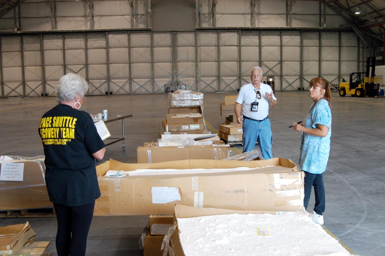 KENNEDY SPACE CENTER, FLA. -   KSC employees check out equipment moved from the Thermal Protection System Facility (TPSF), damaged by Hurricane Frances, to a hangar and storage facility near the KSC Shuttle Landing Facility. Previously, this hangar was used to house the Space Shuttle Columbia debris. Located in Launch Complex 39, the TPSF is used to manufacture both internal and external insulation products for the Space Shuttle orbiters.  The storm's path over Florida took it through Cape Canaveral and KSC property during Labor Day weekend.