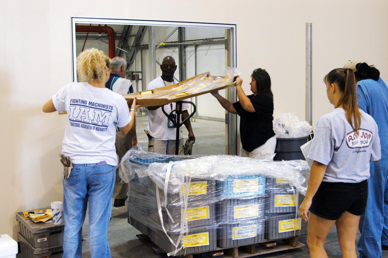 KENNEDY SPACE CENTER, FLA. -   KSC employees move equipment from the Thermal Protection System Facility (TPSF), damaged by Hurricane Frances, into a hangar and storage facility near the KSC Shuttle Landing Facility. Previously, this hangar was used to house the Space Shuttle Columbia debris. Located in Launch Complex 39, the TPSF is used to manufacture both internal and external insulation products for the Space Shuttle orbiters.  The storm's path over Florida took it through Cape Canaveral and KSC property during Labor Day weekend.