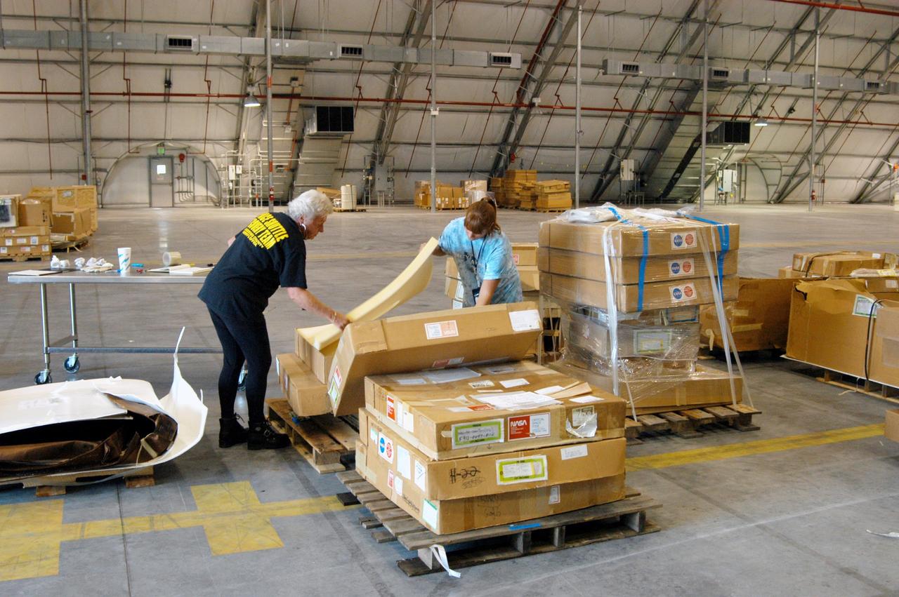 KENNEDY SPACE CENTER, FLA. -   KSC employees move equipment from the Thermal Protection System Facility (TPSF), damaged by Hurricane Frances, into a hangar and storage facility near the KSC Shuttle Landing Facility. Previously, this hangar was used to house the Space Shuttle Columbia debris. Located in Launch Complex 39, the TPSF is used to manufacture both internal and external insulation products for the Space Shuttle orbiters.  The storm's path over Florida took it through Cape Canaveral and KSC property during Labor Day weekend.