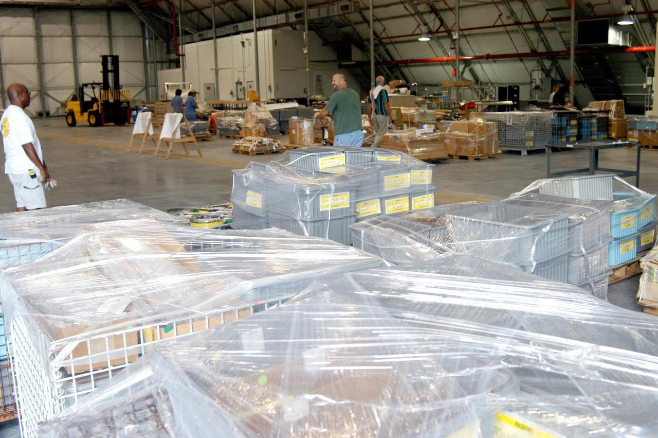 KENNEDY SPACE CENTER, FLA. -   KSC employees move equipment from the Thermal Protection System Facility (TPSF), damaged by Hurricane Frances, into a hangar and storage facility near the KSC Shuttle Landing Facility. Previously, this hangar was used to house the Space Shuttle Columbia debris. Located in Launch Complex 39, the TPSF is used to manufacture both internal and external insulation products for the Space Shuttle orbiters.  The storm's path over Florida took it through Cape Canaveral and KSC property during Labor Day weekend.