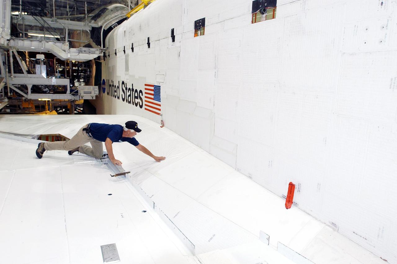 KENNEDY SPACE CENTER, FLA. -   United Space Alliance employee Terry White inspects Space Shuttle Atlantis in the Orbiter Processing Facility following Hurricane Frances. The storm's path over Florida took it through Cape Canaveral and KSC property during Labor Day weekend.  There was no damage to the Space Shuttle orbiters or to any other flight hardware.