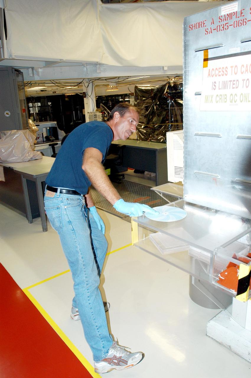 KENNEDY SPACE CENTER, FLA. -   United Space Alliance employee James Calloway checks the temperature and humidity level recorder in the Orbiter Processing Facility following Hurricane Frances. The storm's path over Florida took it through Cape Canaveral and KSC property during Labor Day weekend.  There was no damage to the Space Shuttle orbiters or to any other flight hardware.