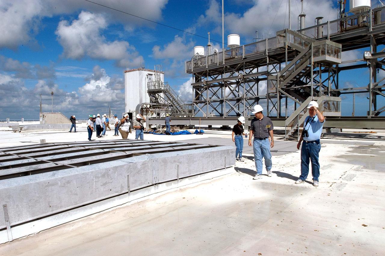 KENNEDY SPACE CENTER, FLA. -   Members of a hurricane assessment team from Johnson Space Center and Marshall Space Flight Center tour the roof of the Vehicle Assembly Building  (VAB) a week after Hurricane Frances hit the east coast of Central Florida and Kennedy Space Center.  The VAB lost 820, 4- x 16-foot panels from the side walls, or more than 52,000 square feet of its surface.
