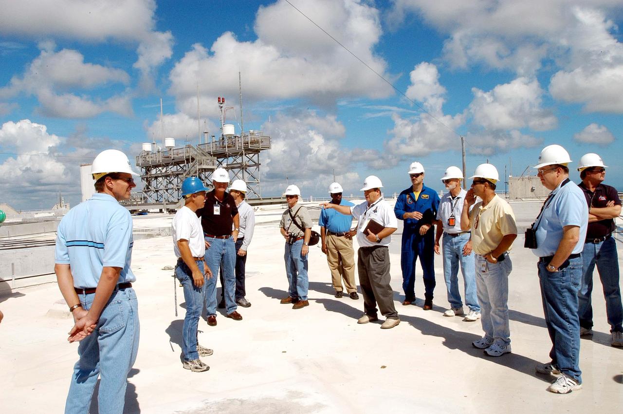 KENNEDY SPACE CENTER, FLA. -   Members of a hurricane assessment team from Johnson Space Center and Marshall Space Flight Center tour the roof of the Vehicle Assembly Building  (VAB) a week after Hurricane Frances hit the east coast of Central Florida and Kennedy Space Center.  The VAB lost 820, 4- x 16-foot panels from the side walls, or more than 52,000 square feet of its surface.  One team member is astronaut Scott Altmann, fifth from right.