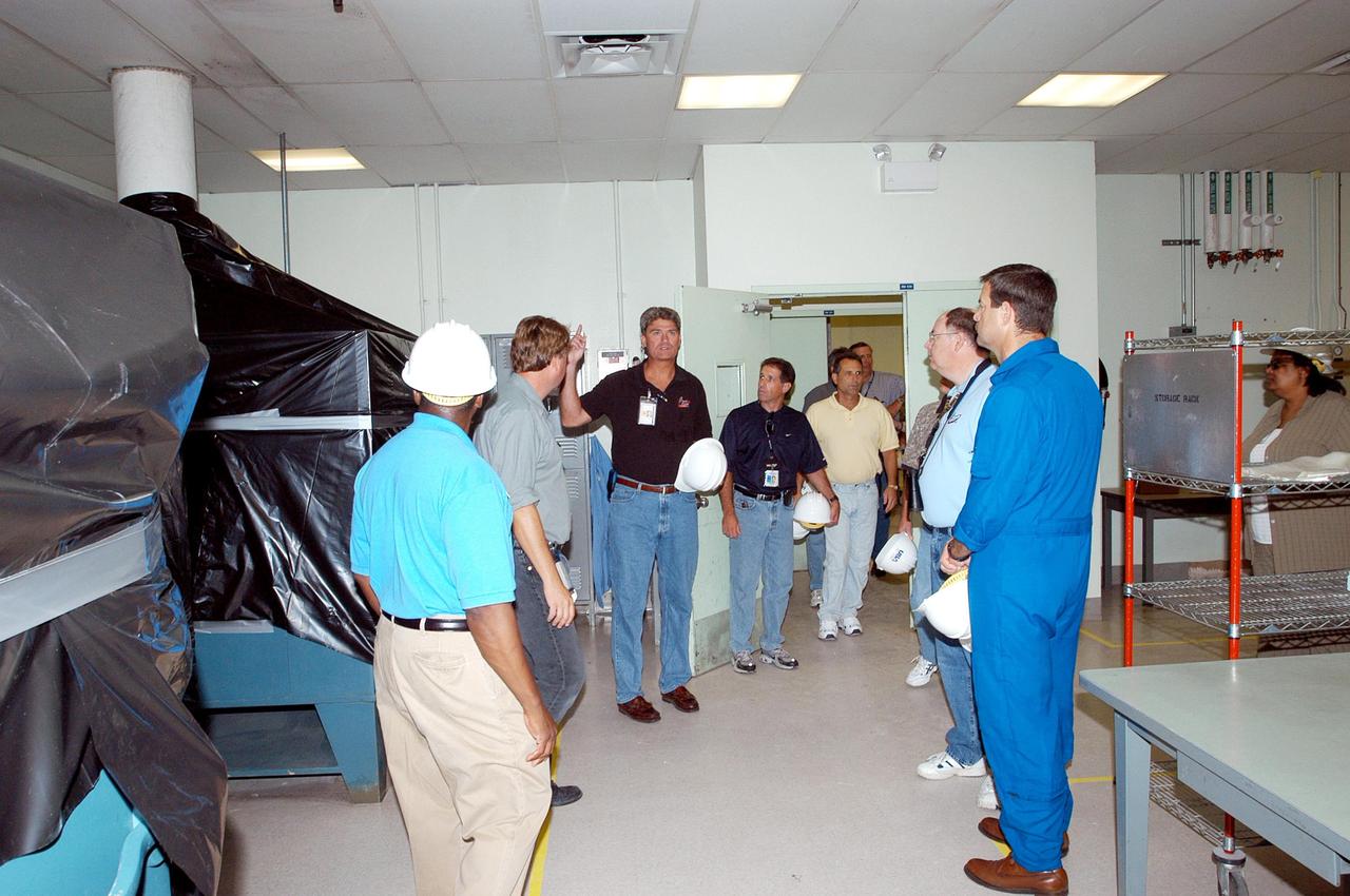 KENNEDY SPACE CENTER, FLA. -  Members of a hurricane assessment team from Johnson Space Center and Marshall Space Flight Center tour the Thermal Protection System (TPS) Facility at KSC after Hurricane Frances hit the east coast of Central Florida and Kennedy Space Center.  At right is astronaut Scott Altmann, a member of the team.  The facility, which creates the TPS tiles, blankets and all the internal thermal control systems for the Space Shuttles, is almost totally unserviceable at this time after losing approximately 35 percent of its roof.  Equipment and materials that survived the storm have been relocated to the RLV hangar near the KSC Shuttle Landing Facility.