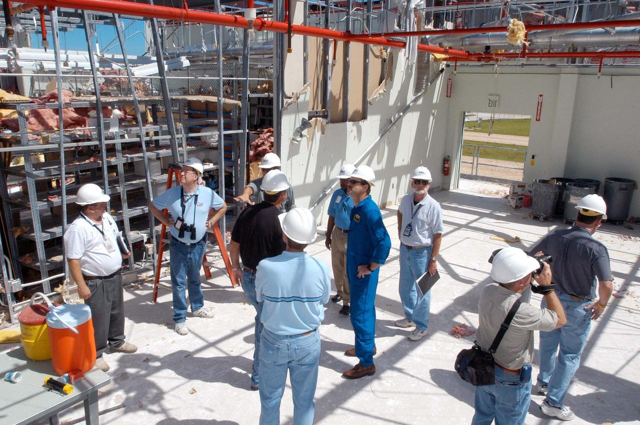 KENNEDY SPACE CENTER, FLA. -  Members of a hurricane assessment team from Johnson Space Center and Marshall Space Flight Center observe the damage to the roof of the Thermal Protection System (TPS) Facility at KSC after Hurricane Frances hit the east coast of Central Florida and Kennedy Space Center.   Near the center is astronaut Scott Altmann, a member of the team.  The facility, which creates the TPS tiles, blankets and all the internal thermal control systems for the Space Shuttles, is almost totally unserviceable at this time after losing approximately 35 percent of its roof.  Equipment and materials that survived the storm have been relocated to the RLV hangar near the KSC Shuttle Landing Facility.