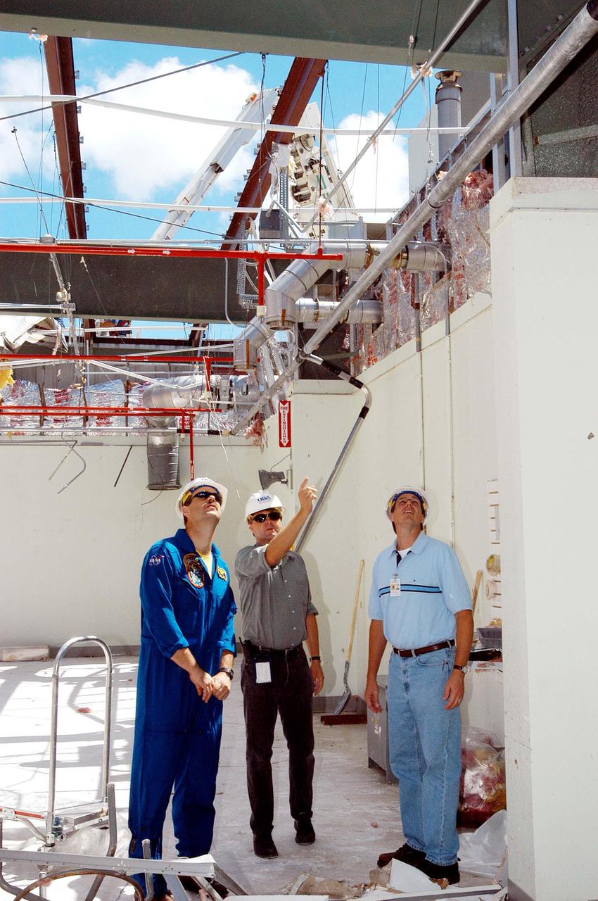 KENNEDY SPACE CENTER, FLA. -  Members of a hurricane assessment team from Johnson Space Center and Marshall Space Flight Center observe the damage to the roof of the Thermal Protection System (TPS) Facility at KSC after Hurricane Frances hit the east coast of Central Florida and Kennedy Space Center.   At left is astronaut Scott Altmann, a member of the team, and at center is Martin Wilson, manager of the TPS operations.  The facility, which creates the TPS tiles, blankets and all the internal thermal control systems for the Space Shuttles, is almost totally unserviceable at this time after losing approximately 35 percent of its roof.  Equipment and materials that survived the storm have been relocated to the RLV hangar near the KSC Shuttle Landing Facility.