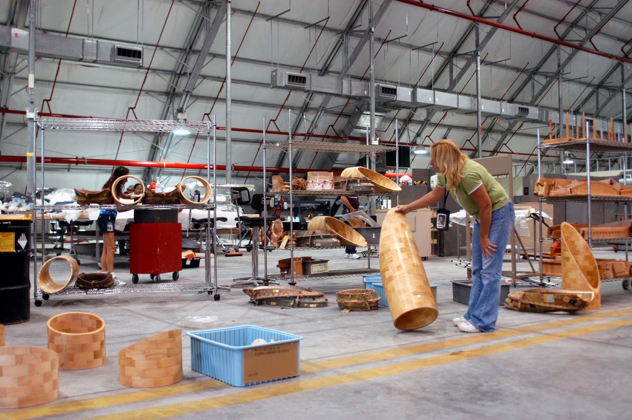 KENNEDY SPACE CENTER, FLA. -  United Space Alliance worker Janet Mills stores equipment removed from the hurricane-ravaged Thermal Protection System Facility (TPSF) in the RLV hangar at KSC.  The TPSF, which creates the TPS tiles, blankets and all the internal thermal control systems for the Space Shuttles, is almost totally unserviceable at this time after losing approximately 35 percent of its roof due to Hurricane Frances, which blew across Central Florida Sept. 4-5.  Undamaged equipment has been moved to the hangar.  The maximum wind at the surface from Hurricane Frances was 94 mph from the northeast at 6:40 a.m. on Sunday, September 5.  It was recorded at a weather tower located on the east shore of the Mosquito Lagoon near the Cape Canaveral National Seashore.  The highest sustained wind at KSC was 68 mph.