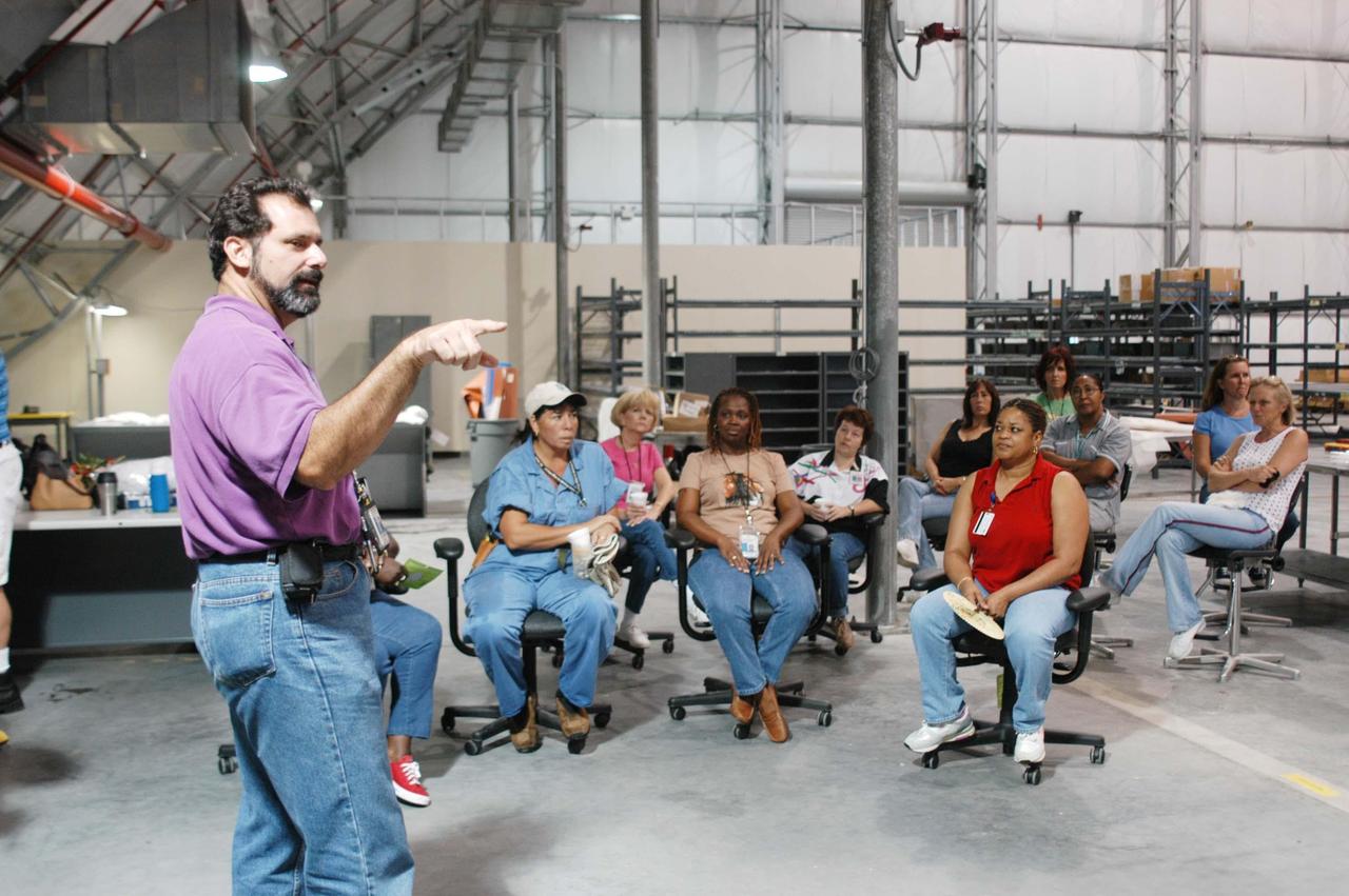 KENNEDY SPACE CENTER, FLA. -  In the RLV hangar at KSC, Steve Harrington talks to workers about the equipment removed from the hurricane-ravaged Thermal Protection System Facility (TPSF) now being stored in the hangar.  The facility, which creates the TPS tiles, blankets and all the internal thermal control systems for the Space Shuttles, is almost totally unserviceable at this time after losing approximately 35 percent of its roof due to Hurricane Frances, which blew across Central Florida Sept. 4-5.  The maximum wind at the surface from Hurricane Frances was 94 mph from the northeast at 6:40 a.m. on Sunday, September 5.  It was recorded at a weather tower located on the east shore of the Mosquito Lagoon near the Cape Canaveral National Seashore.  The highest sustained wind at KSC was 68 mph.