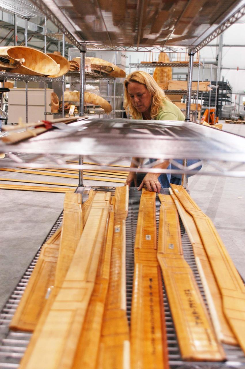 KENNEDY SPACE CENTER, FLA. -  United Space Alliance worker Janet Mills works on equipment in the temporary tile shop set up in the RLV hangar at KSC.  The hurricane-ravaged Thermal Protection System Facility (TPSF), which creates the TPS tiles, blankets and all the internal thermal control systems for the Space Shuttles, is almost totally unserviceable at this time after losing approximately 35 percent of its roof due to Hurricane Frances, which blew across Central Florida Sept. 4-5.  Undamaged equipment was removed from the TPSF and stored in the hangar.  The maximum wind at the surface from Hurricane Frances was 94 mph from the northeast at 6:40 a.m. on Sunday, September 5.  It was recorded at a weather tower located on the east shore of the Mosquito Lagoon near the Cape Canaveral National Seashore.  The highest sustained wind at KSC was 68 mph.