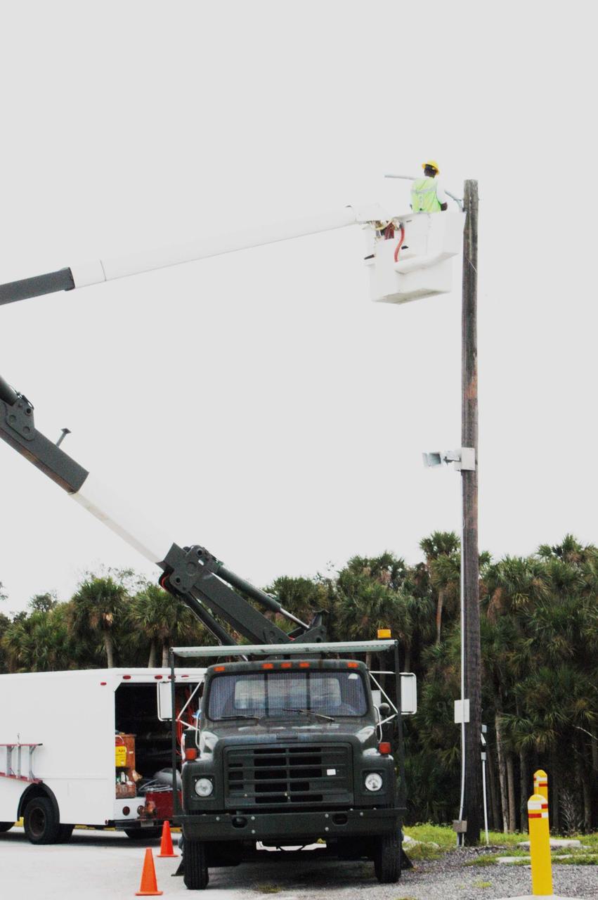 KENNEDY SPACE CENTER, FLA. -  A repair crew replaces a light fixture damaged by Hurricane Frances as it passed over Central Florida during the Labor Day weekend. The maximum wind at the surface from Hurricane Frances was 94 mph from the northeast at 6:40 a.m. on Sunday, September 5.  It was recorded at a weather tower located on the east shore of the Mosquito Lagoon near the Cape Canaveral National Seashore.  The highest sustained wind at KSC was 68 mph.  Hurricane damage sustained at KSC included the south wall and roof of the Vehicle Assembly Building plus the roof of the Thermal Protection System Facility.
