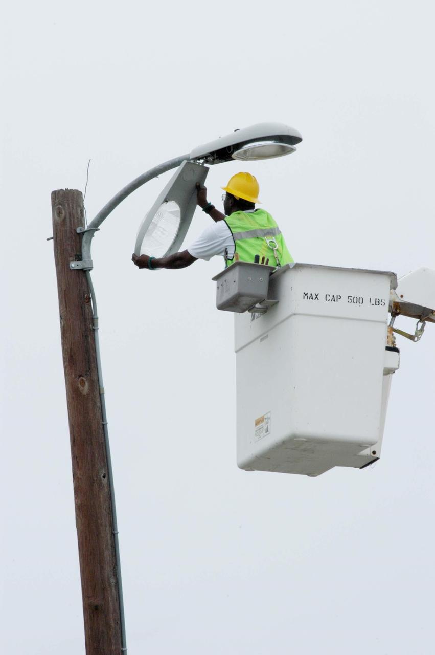 KENNEDY SPACE CENTER, FLA. -  A repair crew replaces a light fixture damaged by Hurricane Frances as it passed over Central Florida during the Labor Day weekend. The maximum wind at the surface from Hurricane Frances was 94 mph from the northeast at 6:40 a.m. on Sunday, September 5.  It was recorded at a weather tower located on the east shore of the Mosquito Lagoon near the Cape Canaveral National Seashore.  The highest sustained wind at KSC was 68 mph.  KSC sustained damage to the south wall and roof of the Vehicle Assembly Building plus the roof of the Thermal Protection System Facility.