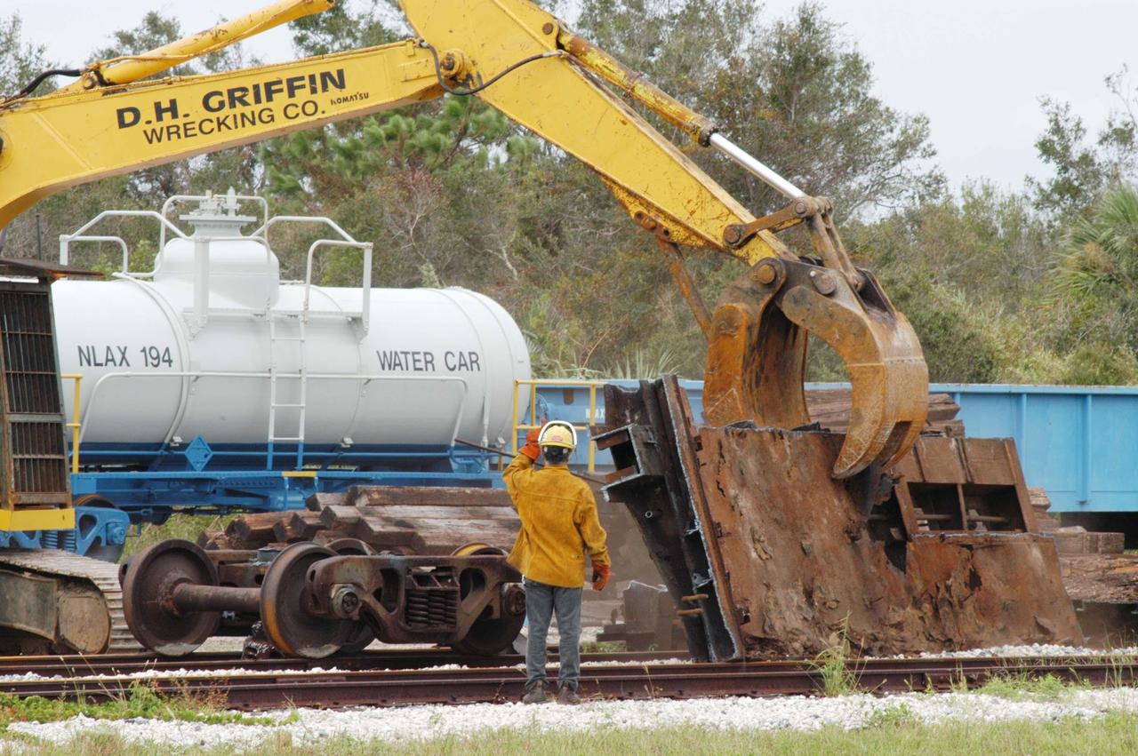 KENNEDY SPACE CENTER, FLA. -  Repair crews clean up debris at the railroad yard left behind after Hurricane Frances as it passed over Central Florida during the Labor Day weekend. The maximum wind at the surface from Hurricane Frances was 94 mph from the northeast at 6:40 a.m. on Sunday, September 5.  It was recorded at a weather tower located on the east shore of the Mosquito Lagoon near the Cape Canaveral National Seashore.  The highest sustained wind at KSC was 68 mph.  KSC sustained damage to the south wall and roof of the Vehicle Assembly Building plus the roof of the Thermal Protection System Facility.