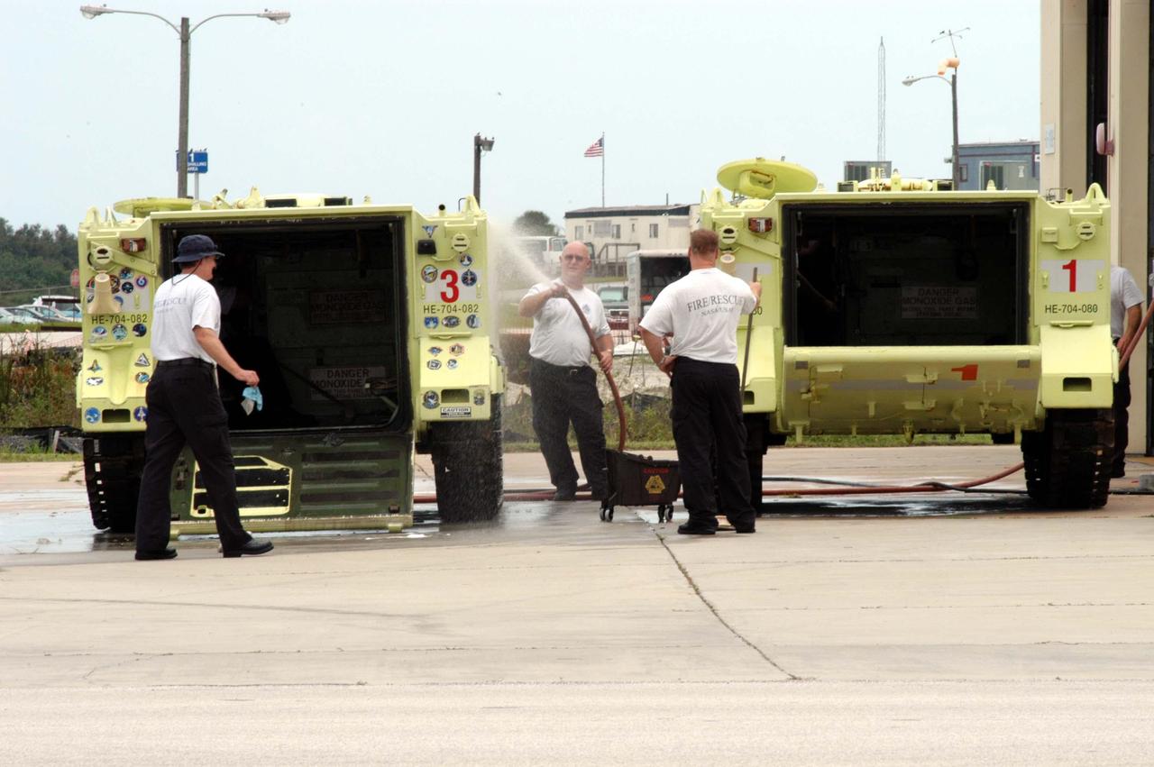 KENNEDY SPACE CENTER, FLA. -  Fire and Rescue team members clean up the vehicles after Hurricane Frances, which passed over Central Florida during the Labor Day weekend. The maximum wind at the surface from Hurricane Frances was 94 mph from the northeast at 6:40 a.m. on Sunday, September 5.  It was recorded at a weather tower located on the east shore of the Mosquito Lagoon near the Cape Canaveral National Seashore.  The highest sustained wind at KSC was 68 mph.