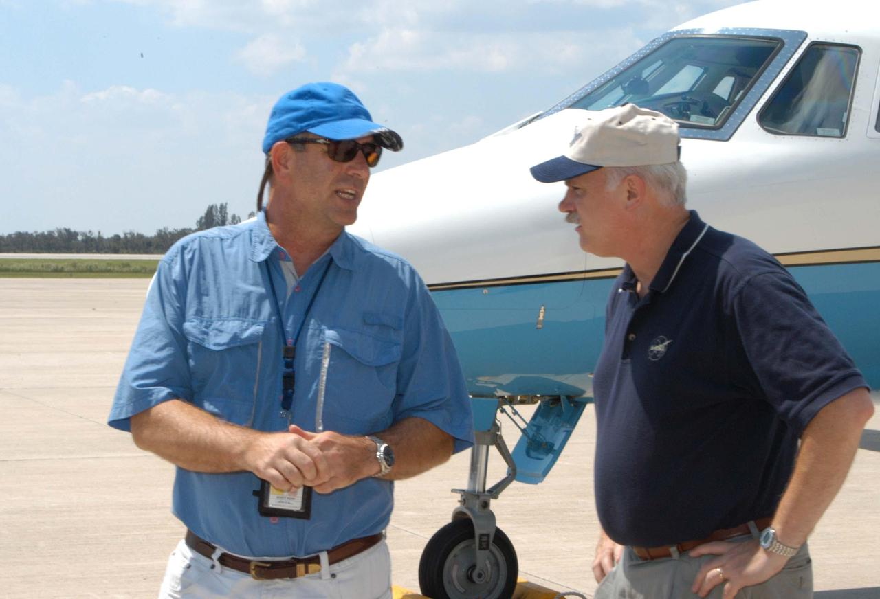 KENNEDY SPACE CENTER, FLA. -  KSC Director of Spaceport Services Scott Kerr (left) talks to NASA Associate Administrator of the Space Operations Mission Directorate William Readdy at the Shuttle Landing Facility.  NASA Administrator Sean O’Keefe and Readdy are visiting KSC to survey the damage sustained by KSC facilities from Hurricane Frances over Labor Day weekend. The Vehicle Assembly Building, Thermal Protection System Facility, and Processing Control Center all received significant damage from the storm.  Additionally, the Operations and Checkout Building, Vertical Processing Facility, Hangar AE, Hangar S and Hangar AF Small Parts Facility each received substantial damage. However, well-protected and unharmed were NASA’s three Space Shuttle orbiters -- Discovery, Atlantis and Endeavour - along with the Shuttle launch pads, all of the critical flight hardware for the orbiters and the International Space Station, and NASA’s Swift spacecraft that is awaiting launch in October.