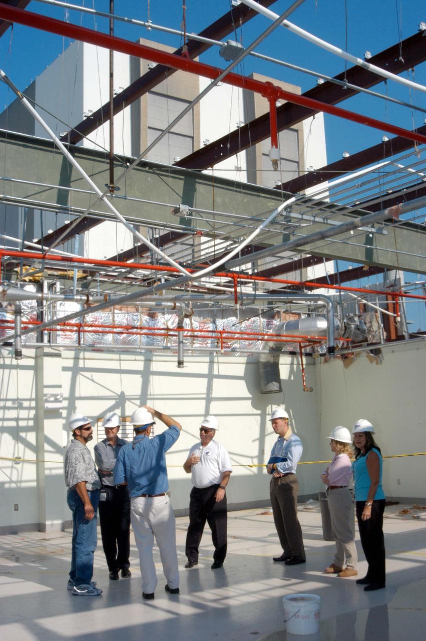 KENNEDY SPACE CENTER, FLA. -  Looking at damage on the second floor of the hurricane-ravaged Thermal Protection System Facility (TPSF) are (from left) Kevin Harrington, manager of Soft Goods Production, TPSF ; Martin Wilson, manager of Thermal Protection System operations for USA; Scott Kerr, KSC director of Spaceport Services; and James Kennedy, Center director.  The TPSF, which creates the TPS tiles, blankets and all the internal thermal control systems for the Space Shuttles, is almost totally unserviceable at this time after losing approximately 35 percent of its roof during Hurricane Frances, which blew across Central Florida Sept. 4-5.  Undamaged equipment was removed from the TPSF and stored in the RLV hangar. NASA Administrator Sean O’Keefe and NASA Associate Administrator of  Space Operations Mission Directorate William Readdy are visiting KSC to survey the damage sustained by KSC facilities from the hurricane.  The Labor Day storm also caused significant damage to the Vehicle Assembly Building and Processing Control Center.  Additionally, the Operations and Checkout Building, Vertical Processing Facility, Hangar AE, Hangar S and Hangar AF Small Parts Facility each received substantial damage. However, well-protected and unharmed were NASA’s three Space Shuttle orbiters - Discovery, Atlantis and Endeavour - along with the Shuttle launch pads, all of the critical flight hardware for the orbiters and the International Space Station, and NASA’s Swift spacecraft that is awaiting launch in October.